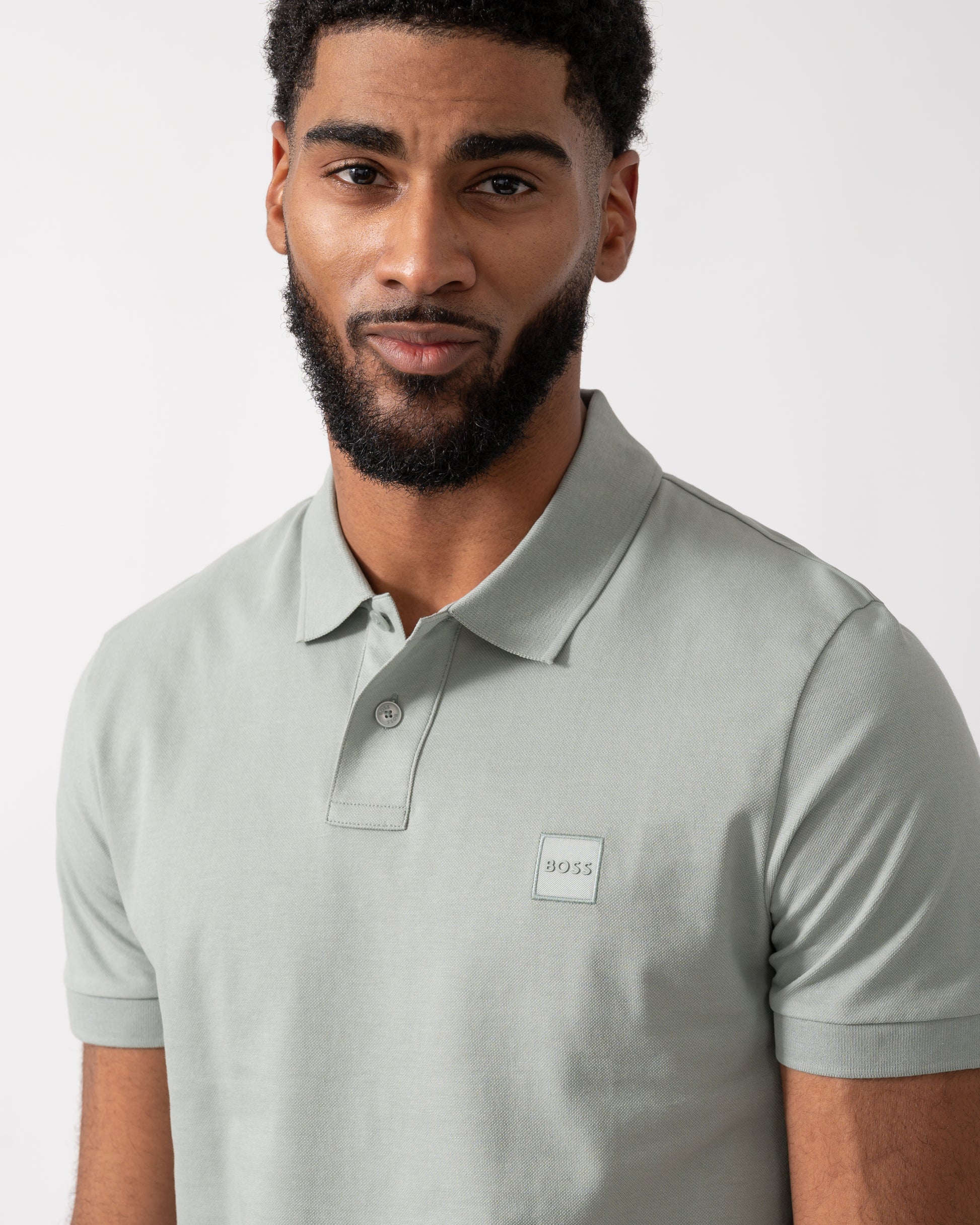 close up of a Model wearing a BOSS Orange Passenger Mens Stretch-Cotton Slim-Fit Polo Shirt with Logo Patch in Open Green