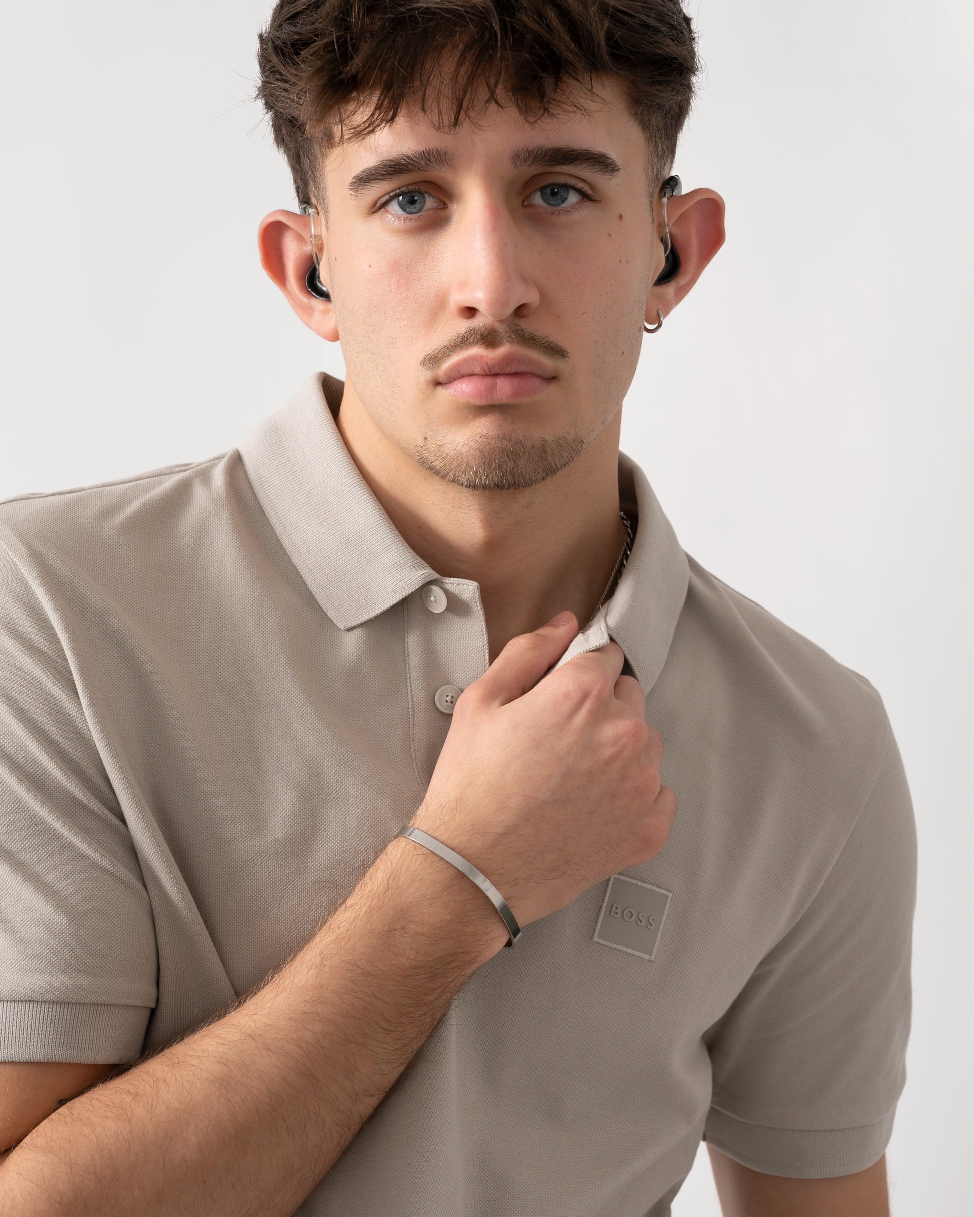 close up shot of a model wearing a BOSS Orange Passenger Mens Stretch-Cotton Slim-Fit Polo Shirt with Logo Patch in Open Grey 070
