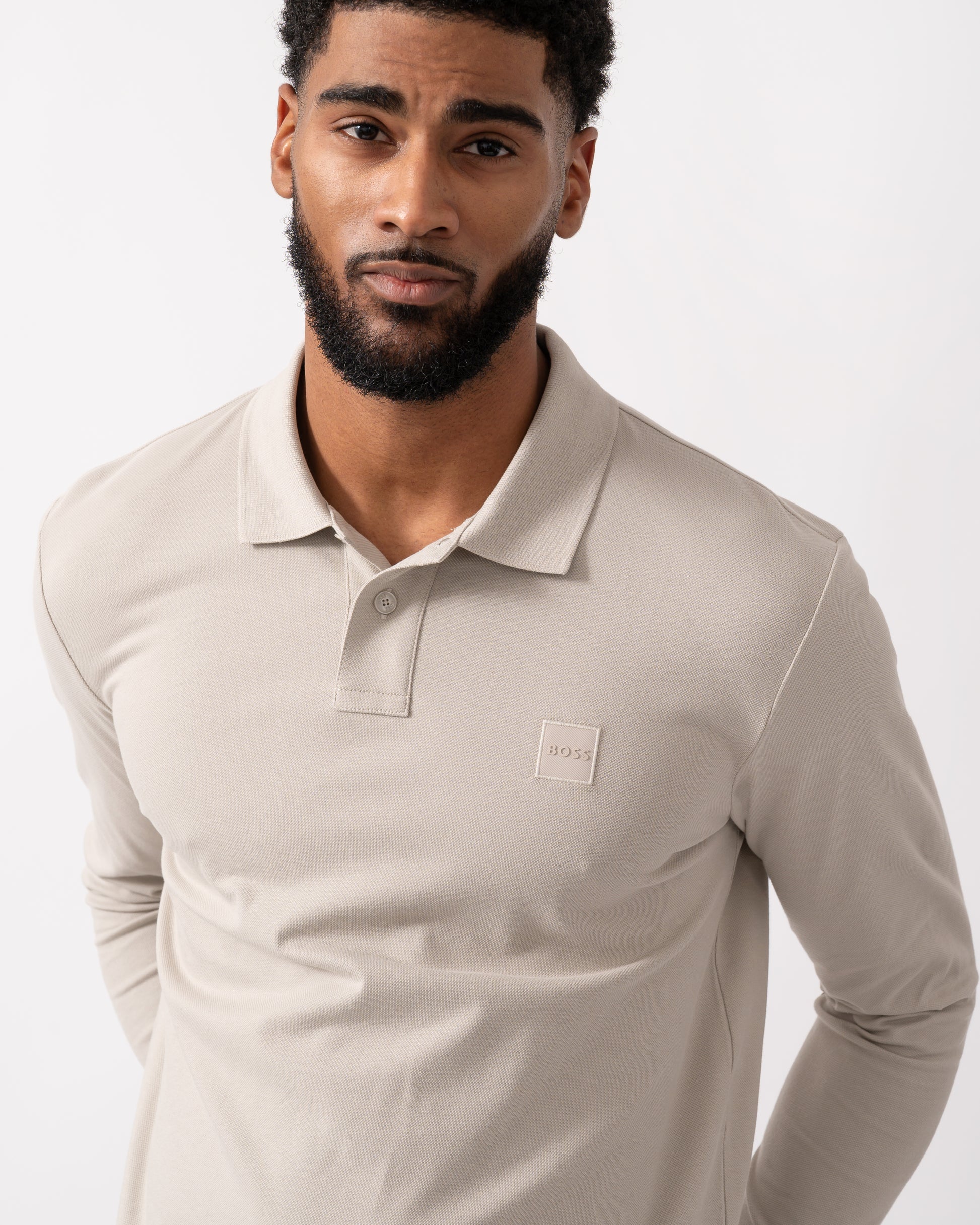 detail shot of a model wearing a BOSS Orange Passerby Mens Long Sleeve Stretch-Cotton Polo Shirt with Logo Patch in Open Grey