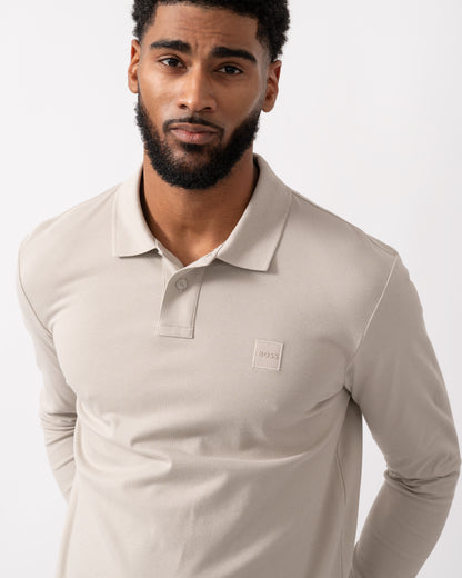 detail shot of a model wearing a BOSS Orange Passerby Mens Long Sleeve Stretch-Cotton Polo Shirt with Logo Patch in Open Grey