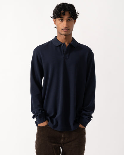 studio photograph showing a model wearing a BOSS Orange Petempestolong Mens Long Sleeve Polo Shirt in Dark Blue 404