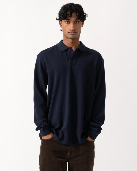 studio photograph showing a model wearing a BOSS Orange Petempestolong Mens Long Sleeve Polo Shirt in Dark Blue 404