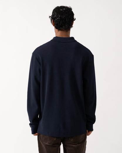 studio photograph showing the back of a model wearing a BOSS Orange Petempestolong Mens Long Sleeve Polo Shirt in Dark Blue 404