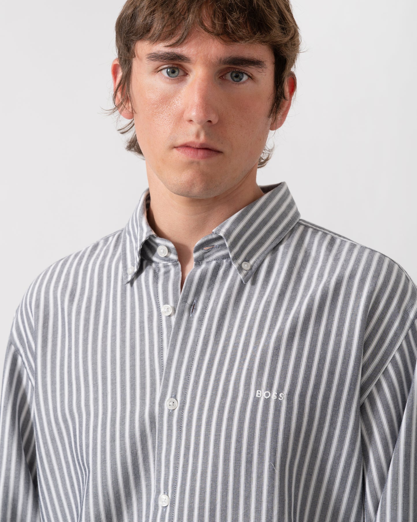 detail of model wearing a BOSS Orange Ricoplus Mens Long Sleeve Oxford Shirt in Dark Blue 404