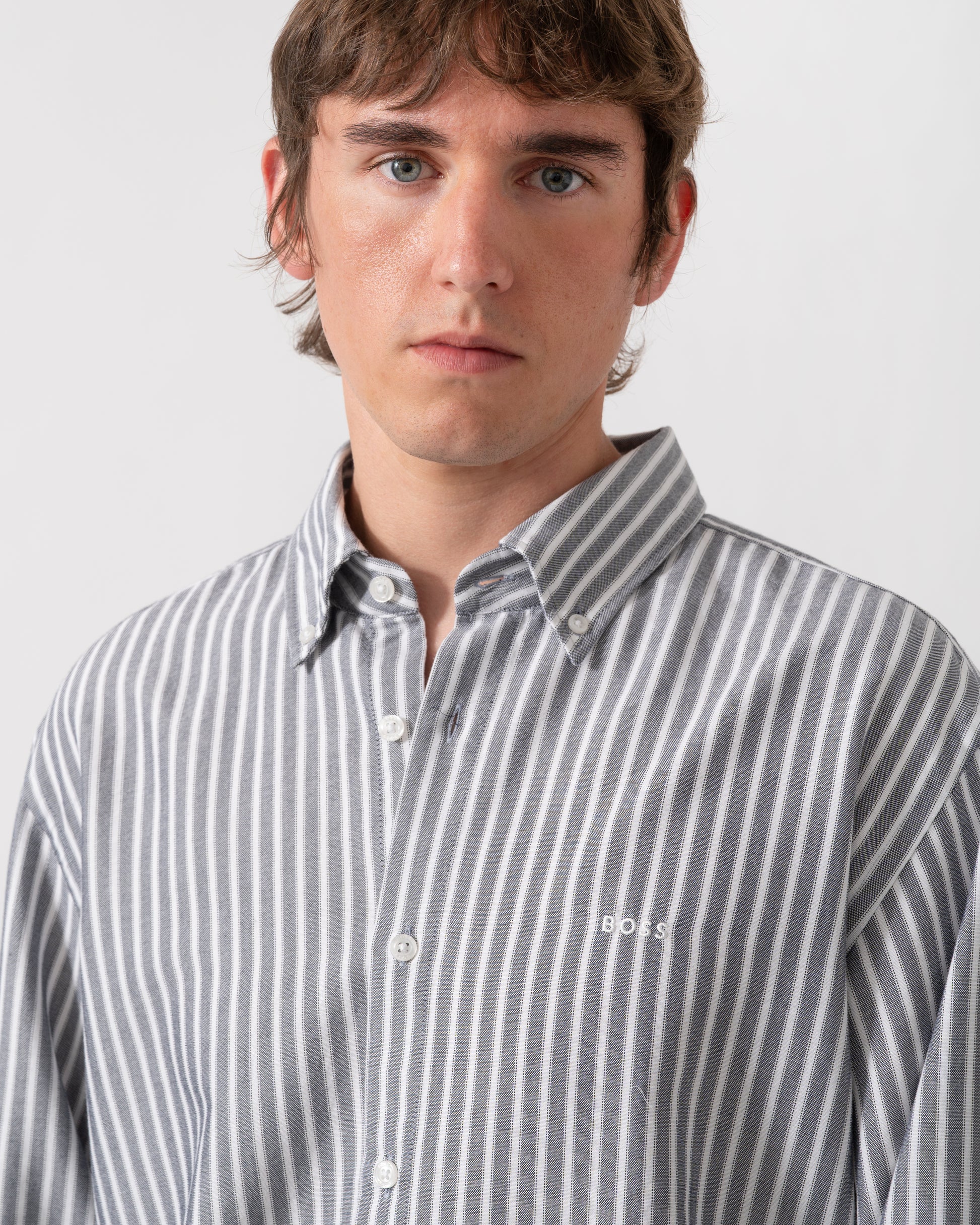detail of model wearing a BOSS Orange Ricoplus Mens Long Sleeve Oxford Shirt in Dark Blue 404