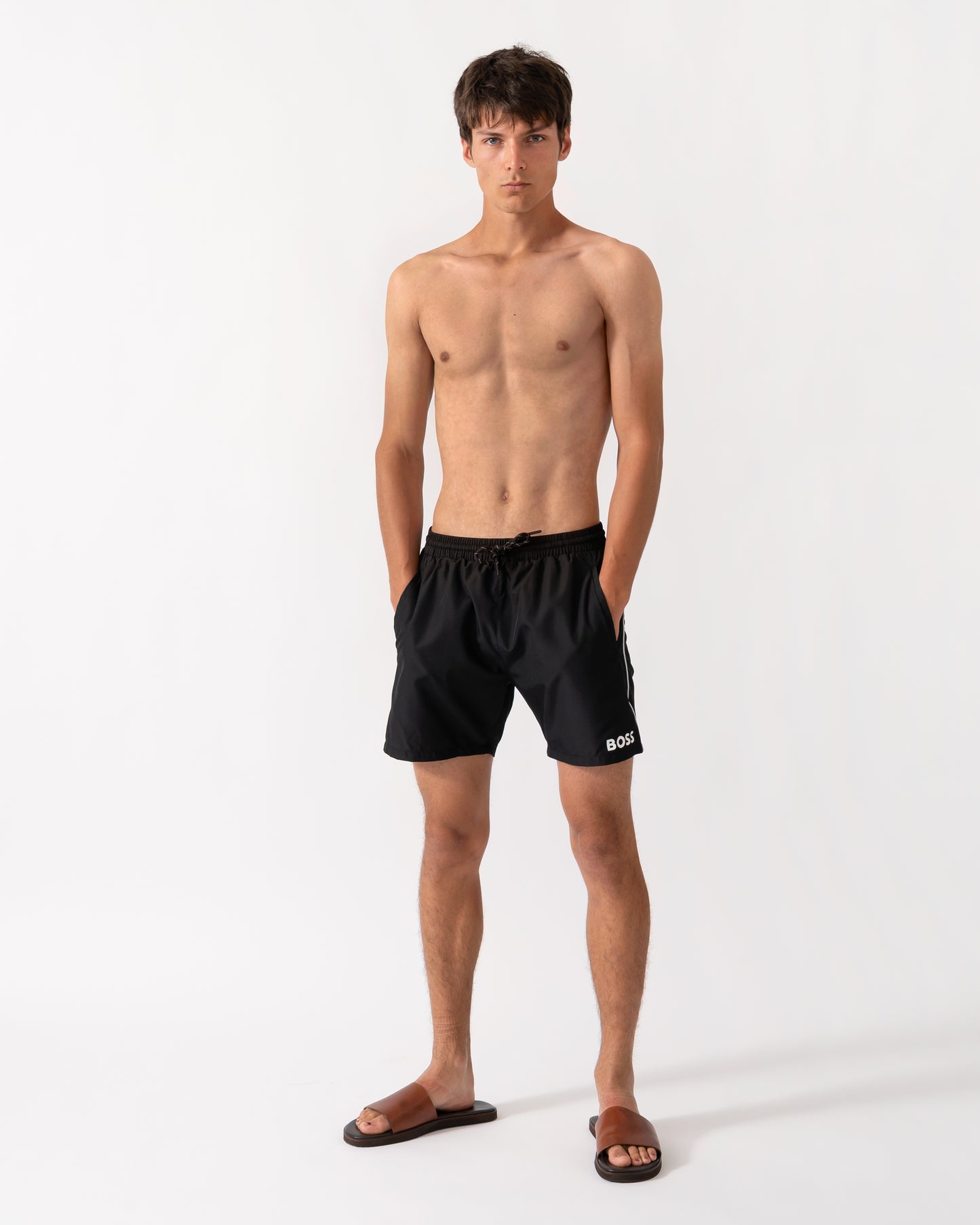 full length shot of a model wearing a pair of BOSS Orange Starfish Mens Swim Shorts in Black 001