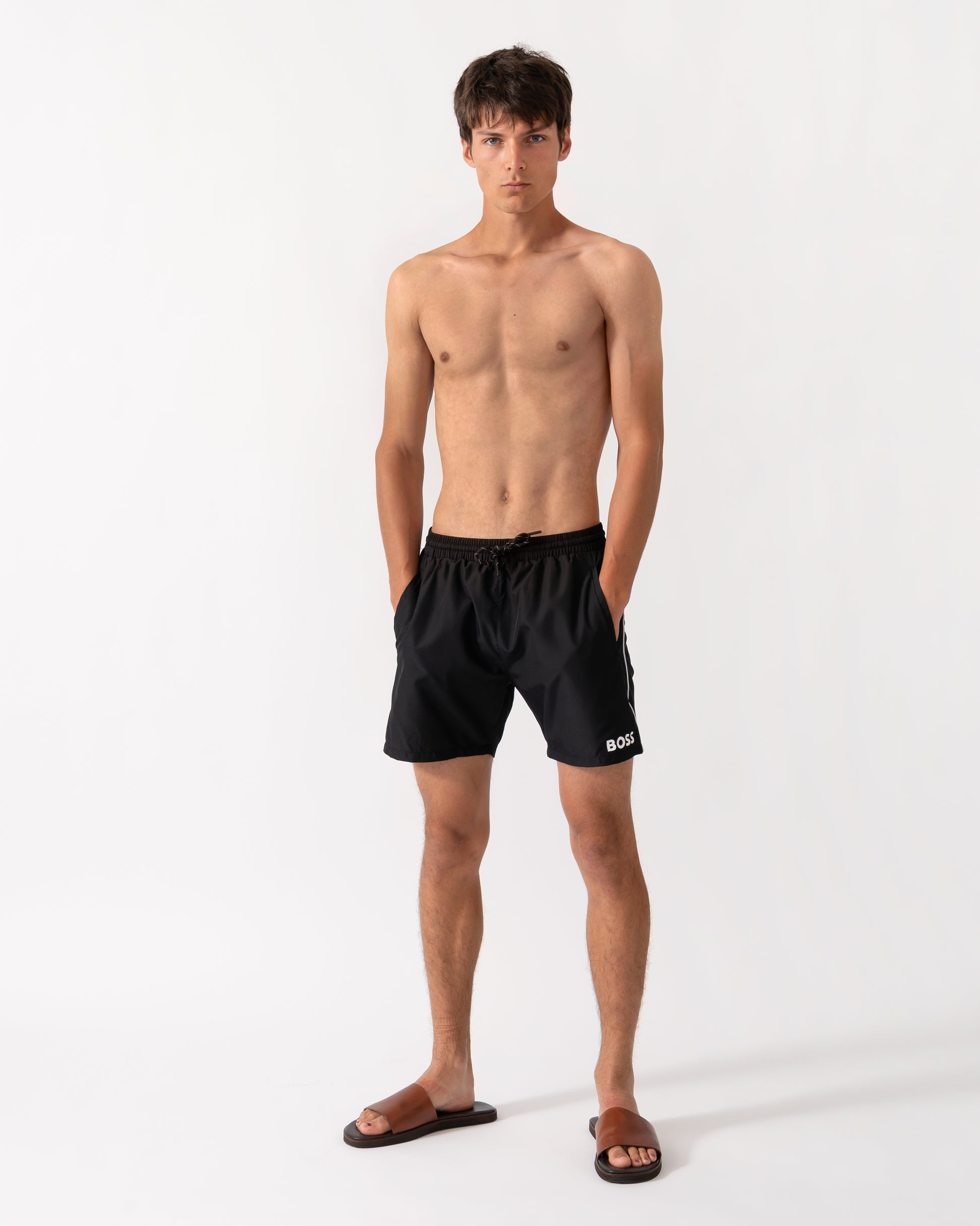 full length shot of a model wearing a pair of BOSS Orange Starfish Mens Swim Shorts in Black 001