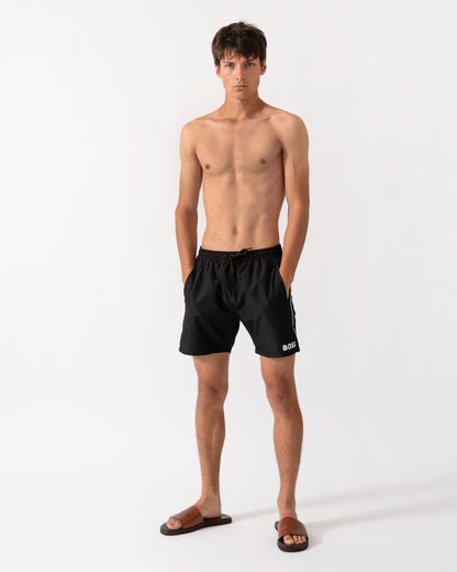 full length shot of a model wearing a pair of BOSS Orange Starfish Mens Swim Shorts in Black 001