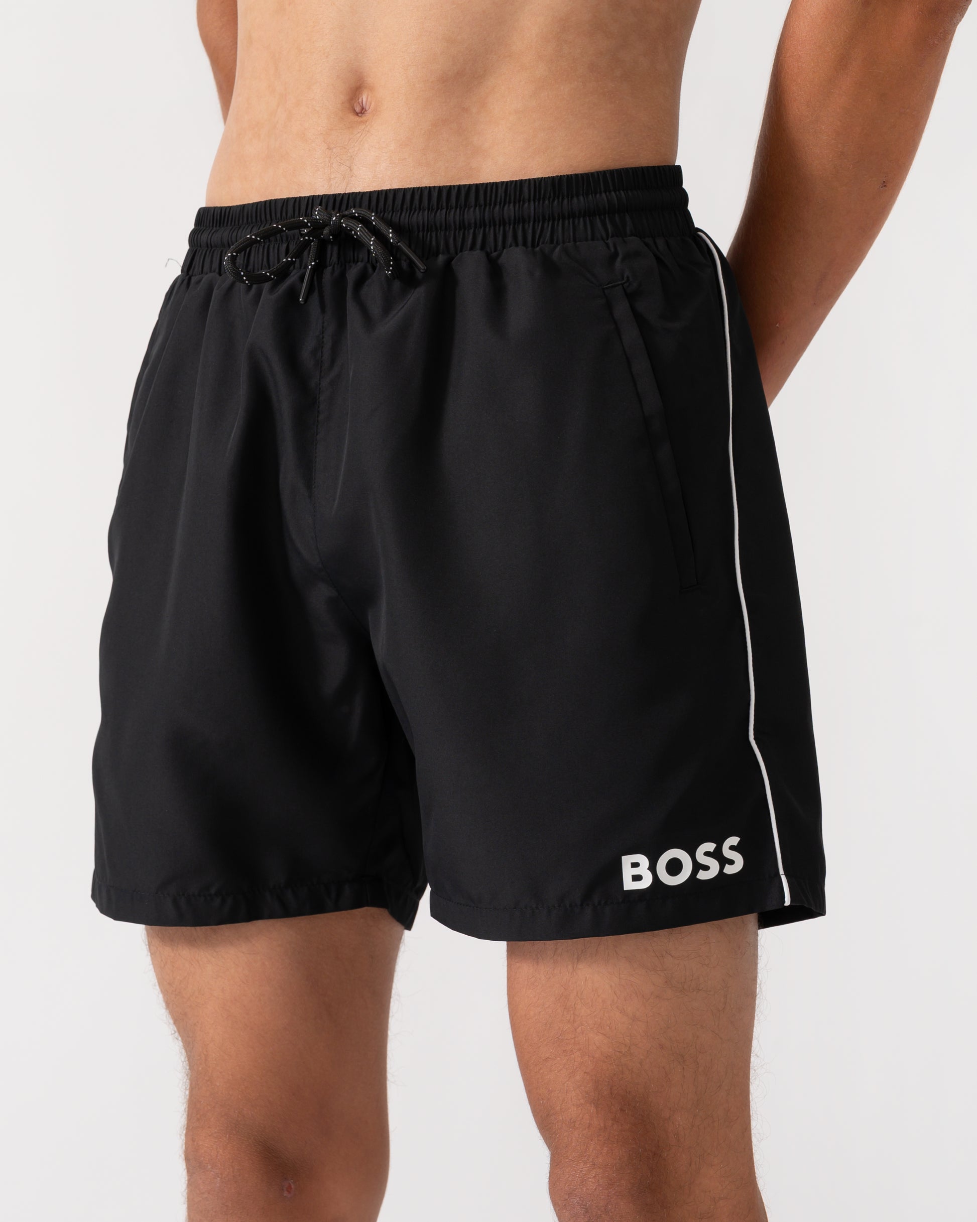 close up of a model wearing a pair of BOSS Orange Starfish Mens Swim Shorts in Black 001