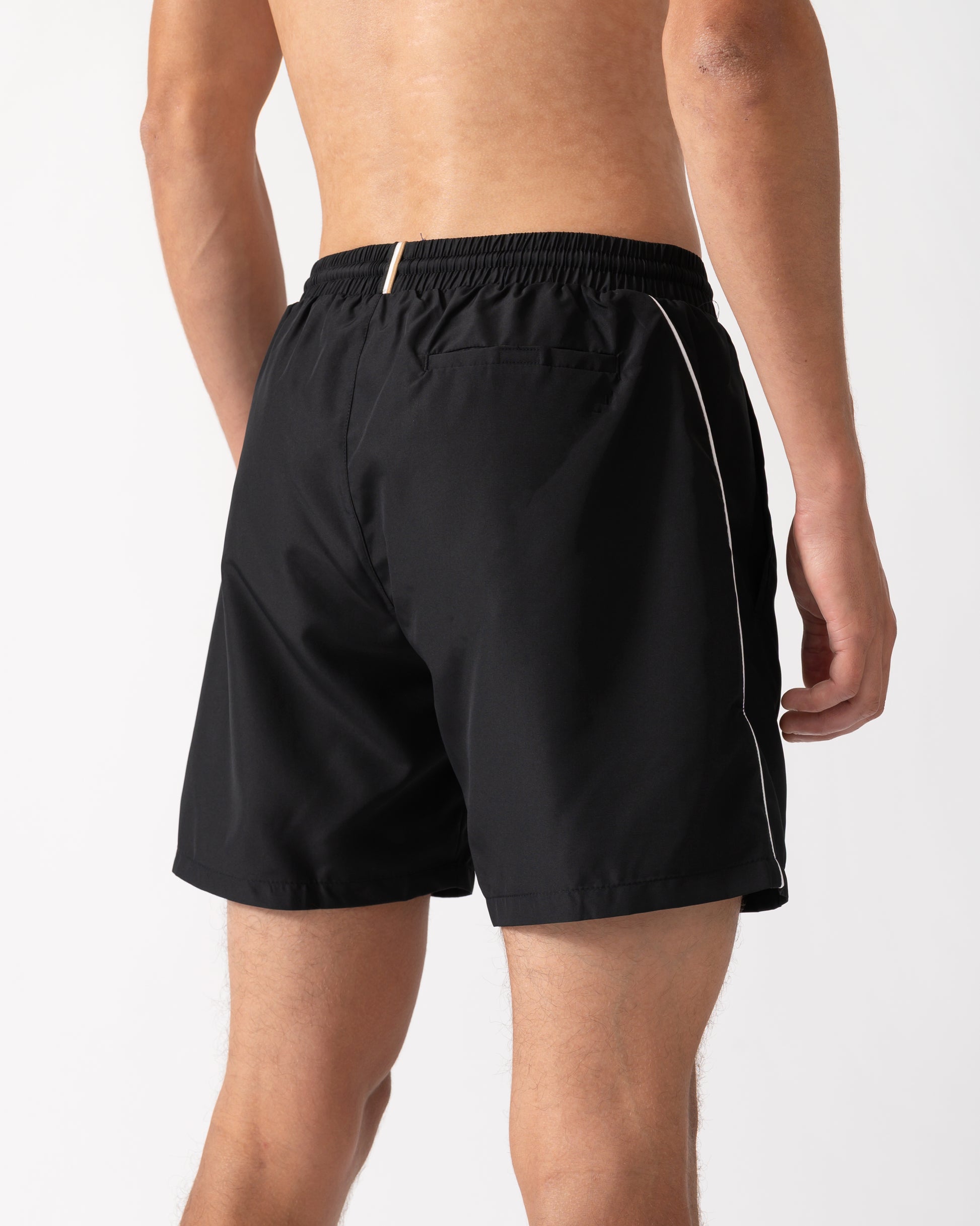 back shot of a model wearing a pair of BOSS Orange Starfish Mens Swim Shorts in Black 001