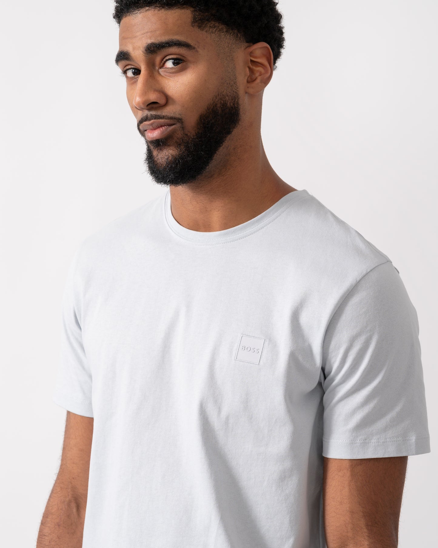 close up of a model wearing a BOSS Orange Tales Mens Cotton-Jersey T-shirt With Logo Patch in Light-Pastel Grey