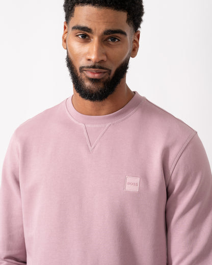 close up of a a model wearing a BOSS Orange Westart Mens Crew Neck Sweatshirt With Logo Patch in Light Pastel Purple