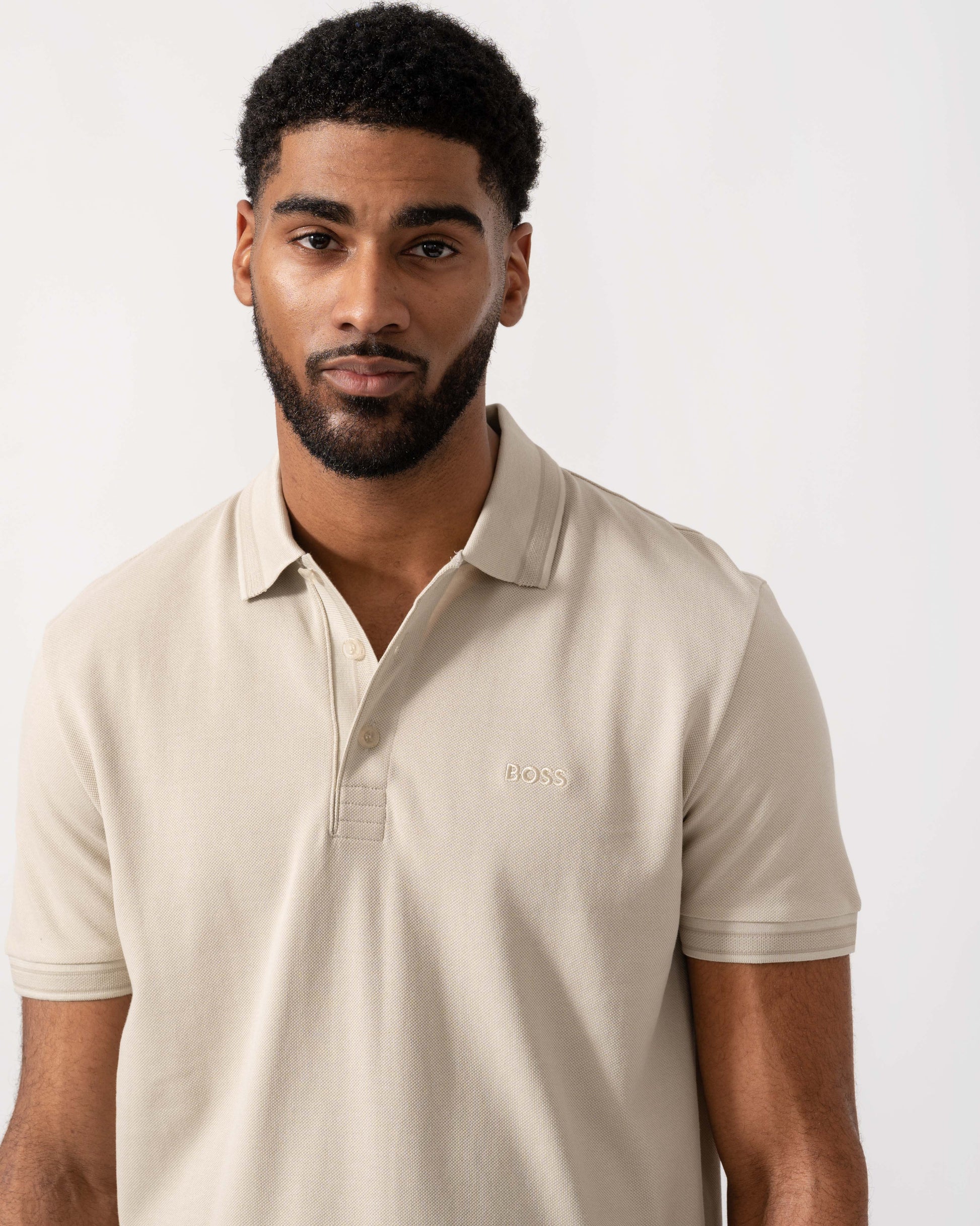 Model wearing BOSS Green Mens Paddy Cotton-Piqué Polo Shirt with Contrast Logo in Light Beige 275 - Detail