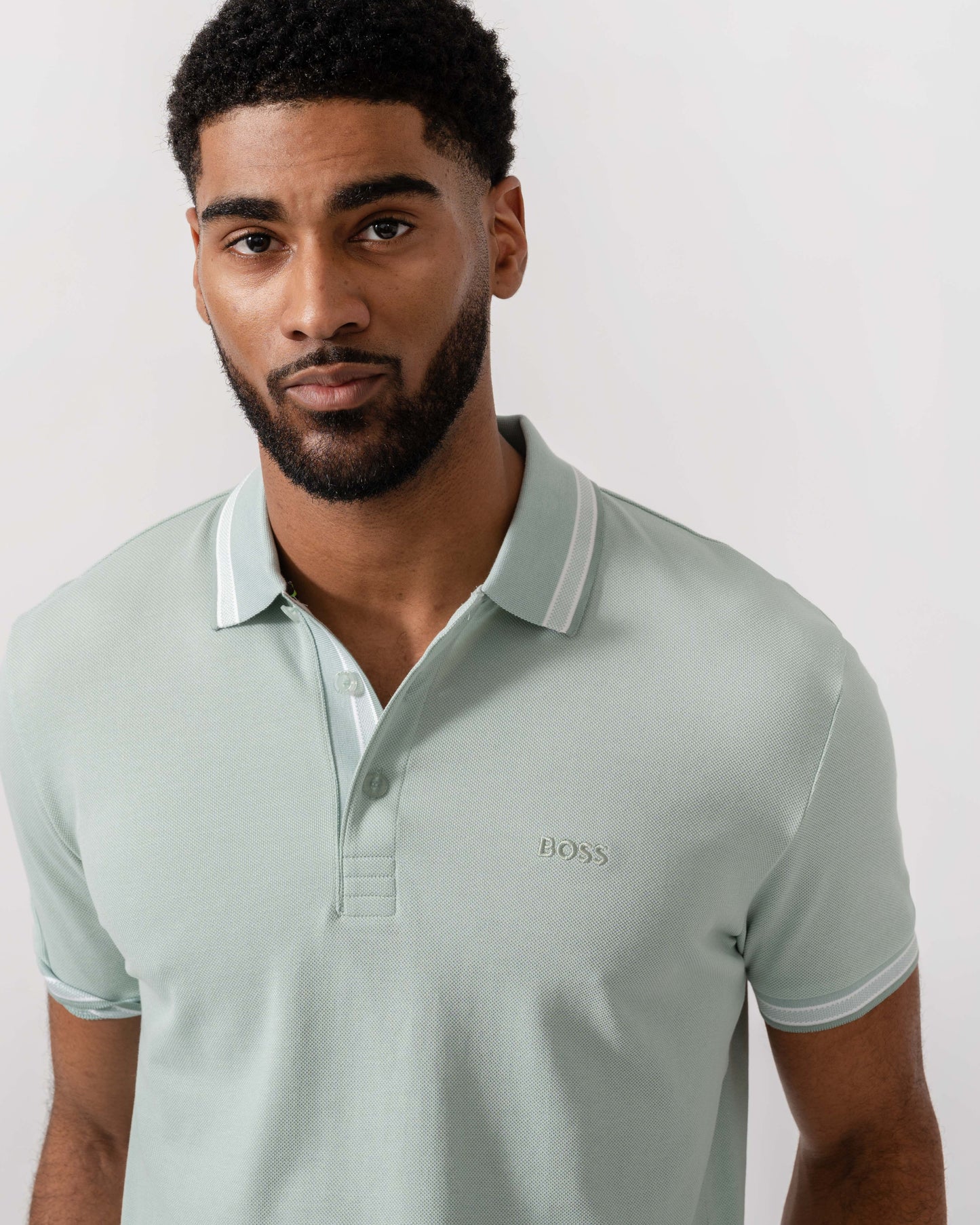 Model wearing BOSS Green Mens Paddy Cotton-Piqué Polo Shirt with Contrast Logo in Turquoise/Aqua 448 - Detail