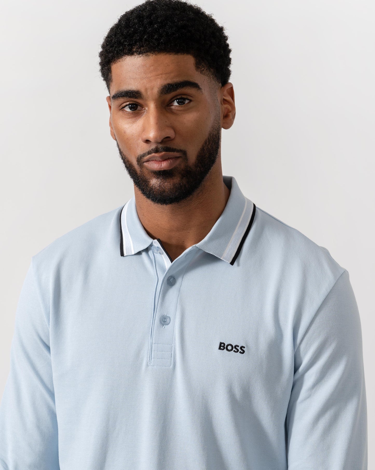 Model wearing BOSS Green Mens Plisy Long Sleeve Polo Shirt in Open Blue 464 - Detail
