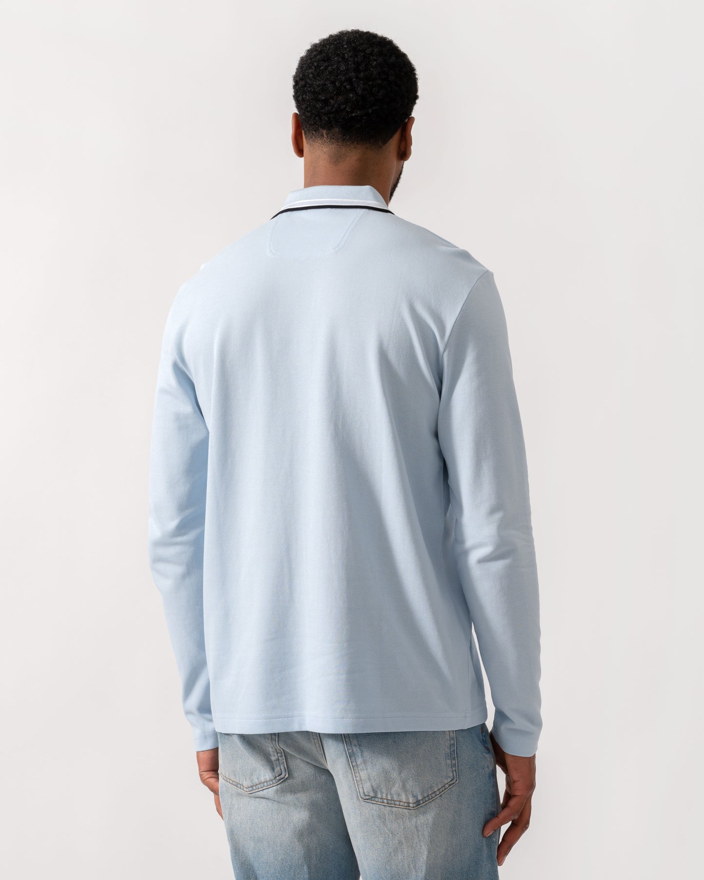 Model wearing BOSS Green Mens Plisy Long Sleeve Polo Shirt in Open Blue 464 - Back