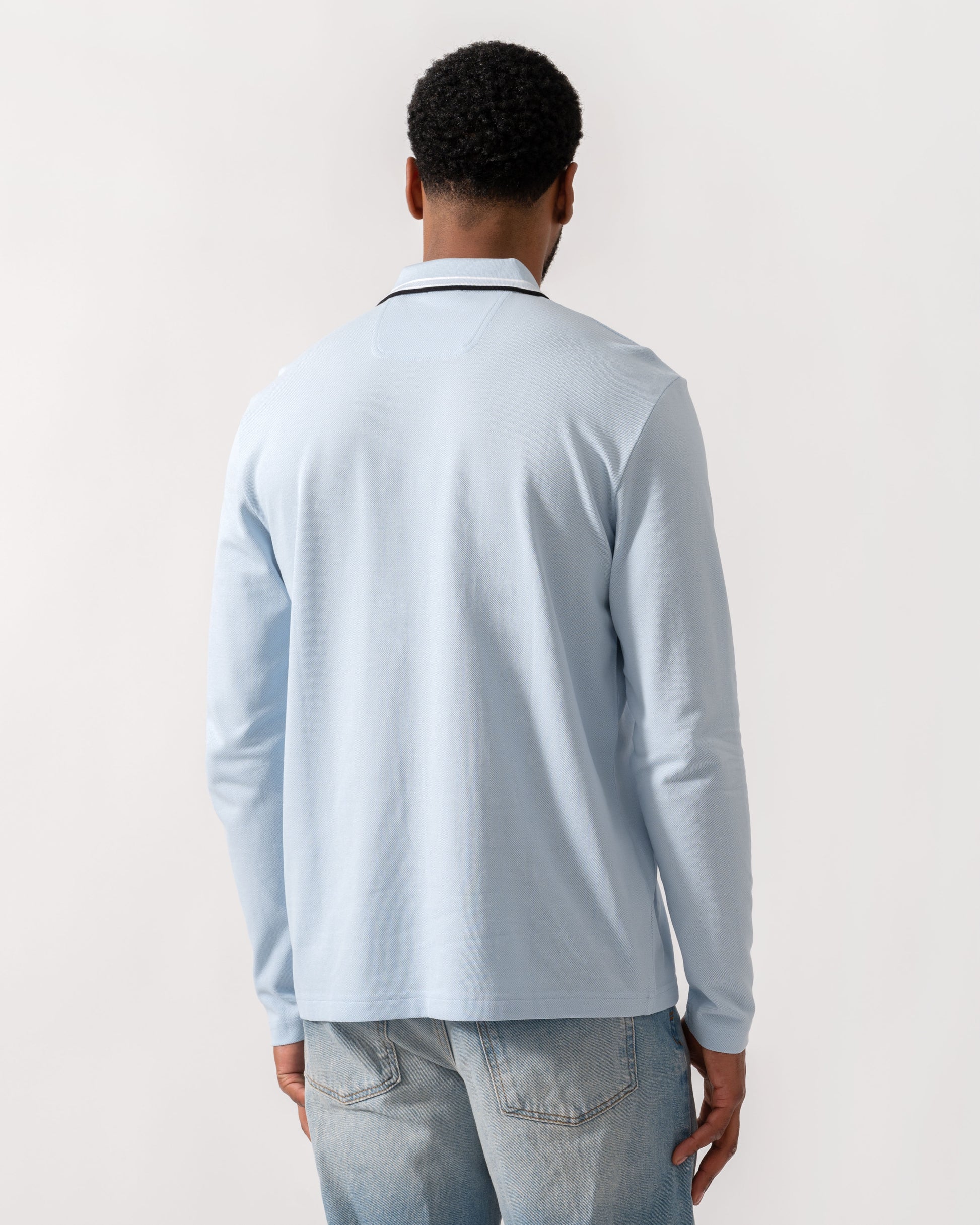 Model wearing BOSS Green Mens Plisy Long Sleeve Polo Shirt in Open Blue 464 - Back