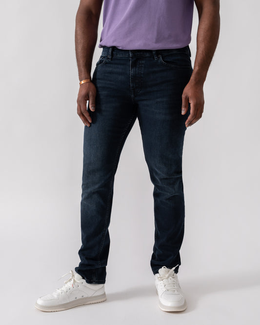 Model wearing BOSS Orange Delaware Slim-Fit Jeans in Blue-Black Soft-Motion Denim in Dark Blue 405 - Main