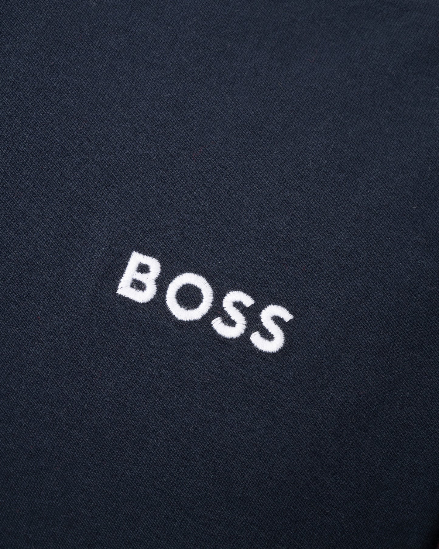 Close-up of a black fabric with 'BOSS' embroidered in white.