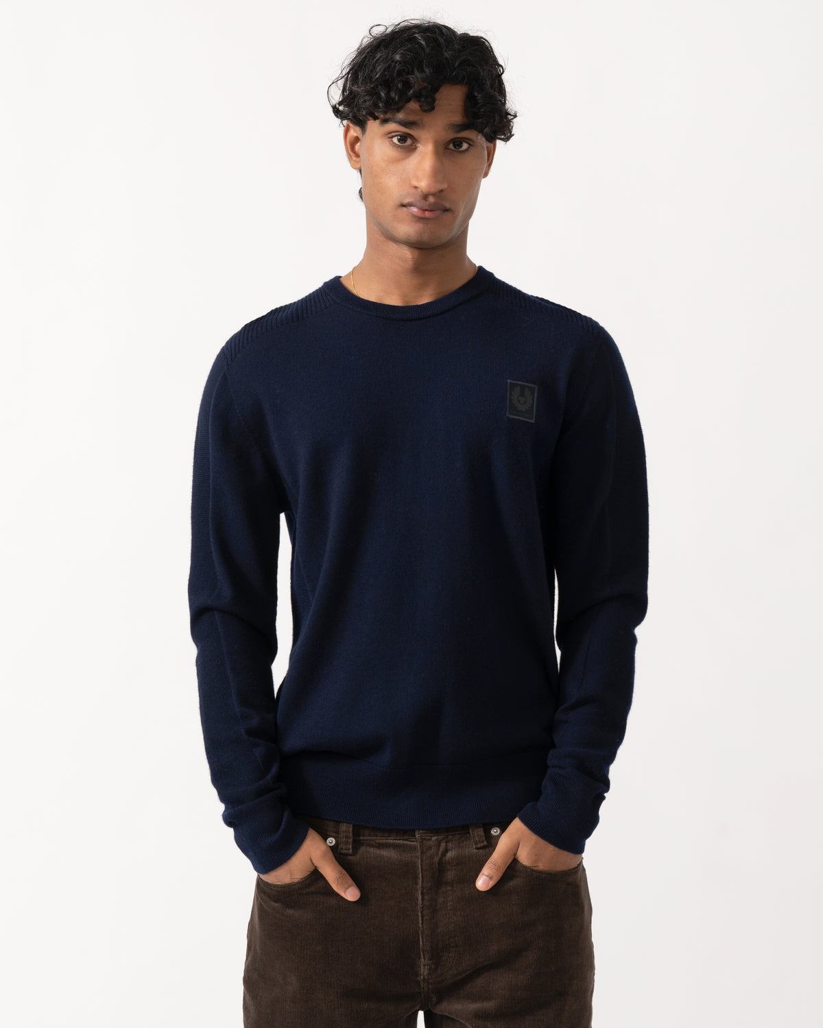 Studio photograph of a model wearing a Belstaff Mens Colden Merino Crew Neck Jumper in Dark Ink