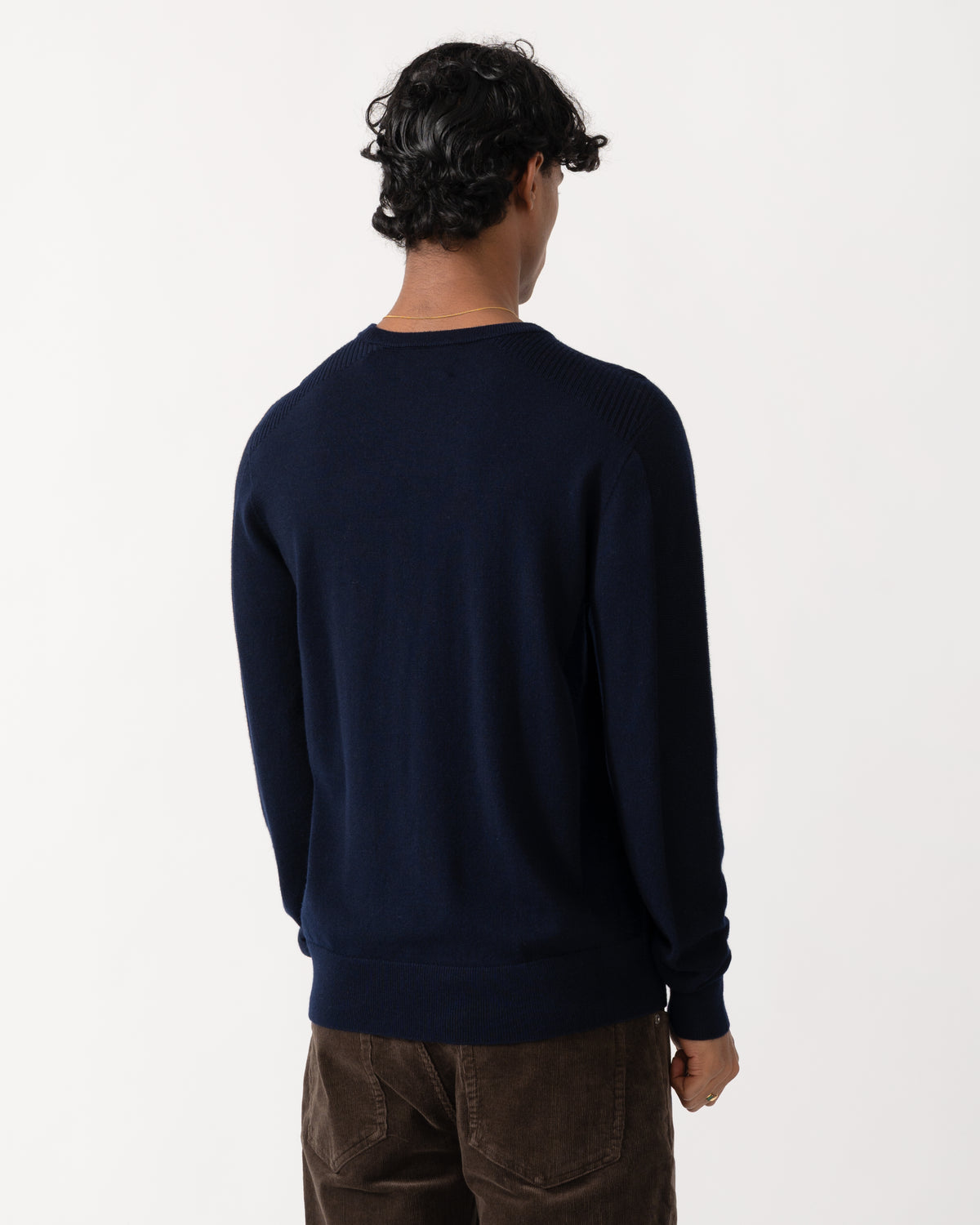 Studio photograph showing the back of a model wearing a Belstaff Mens Colden Merino Crew Neck Jumper in Dark Ink
