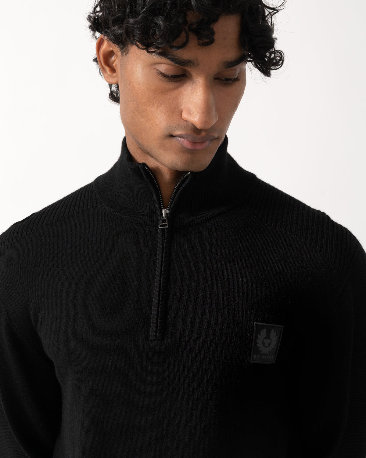 close up Studio photograph of a model wearing a Belstaff Mens Colden Merino Quarter Zip Jumper in Black
