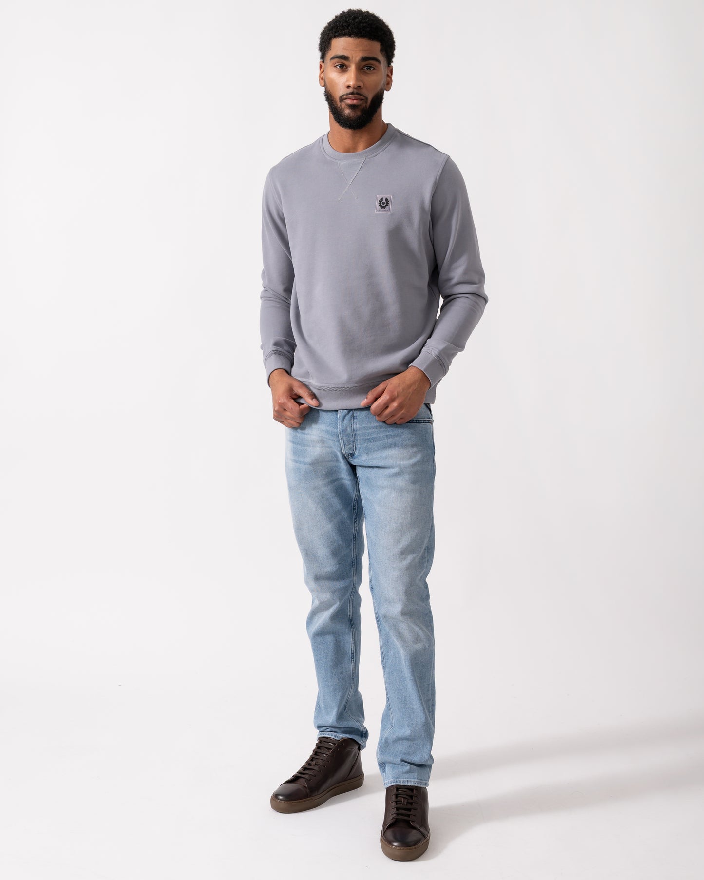 Full length shot of a Model wearing a Belstaff Mens Crew Neck Sweatshirt With Logo Patch in Faded Indigo