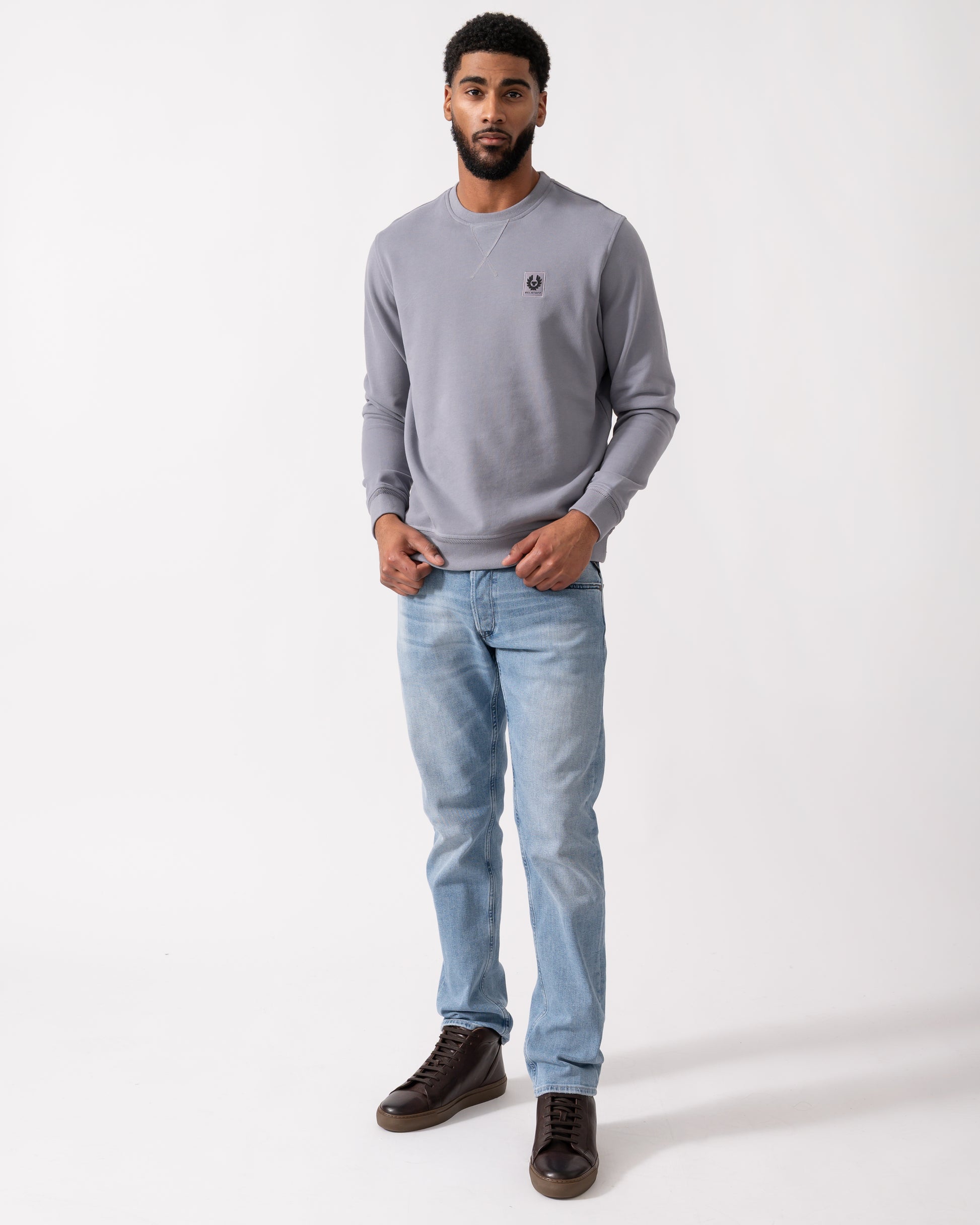 Full length shot of a Model wearing a Belstaff Mens Crew Neck Sweatshirt With Logo Patch in Faded Indigo