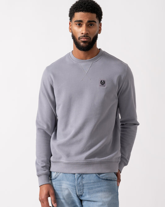 Model wearing a Belstaff Mens Crew Neck Sweatshirt With Logo Patch in Faded Indigo