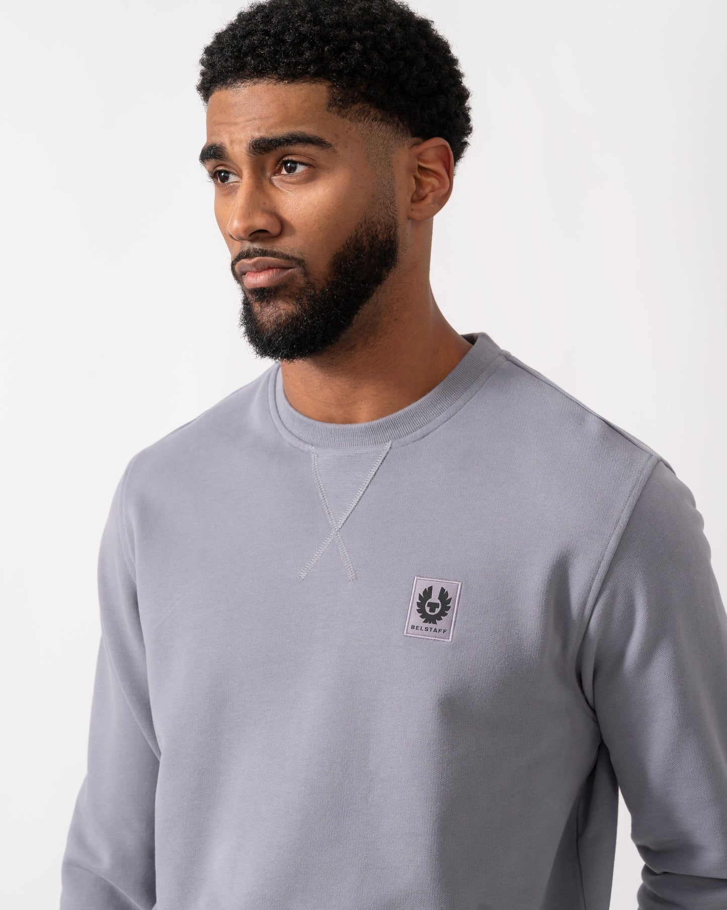close up of a Model wearing a Belstaff Mens Crew Neck Sweatshirt With Logo Patch in Faded Indigo