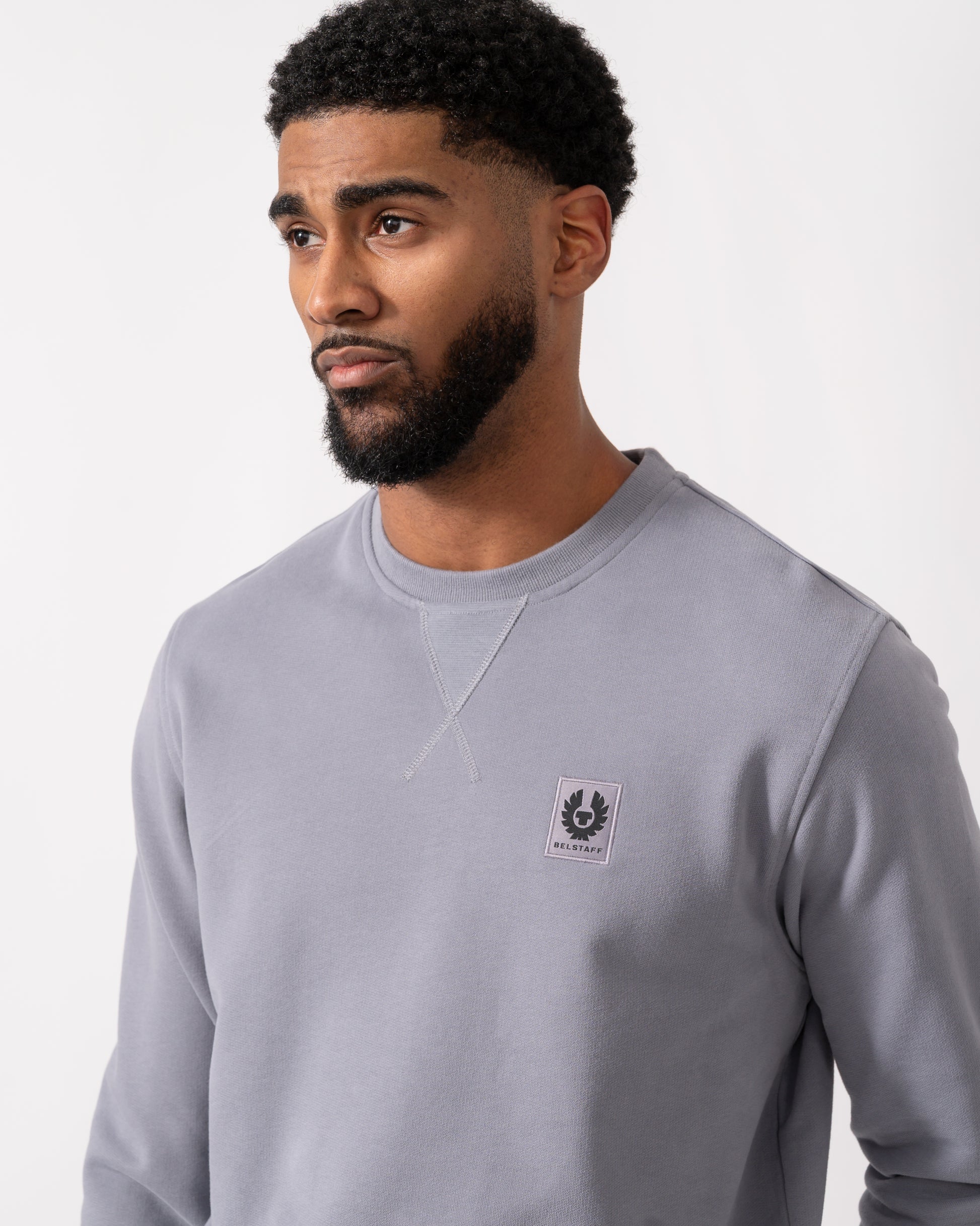 close up of a Model wearing a Belstaff Mens Crew Neck Sweatshirt With Logo Patch in Faded Indigo