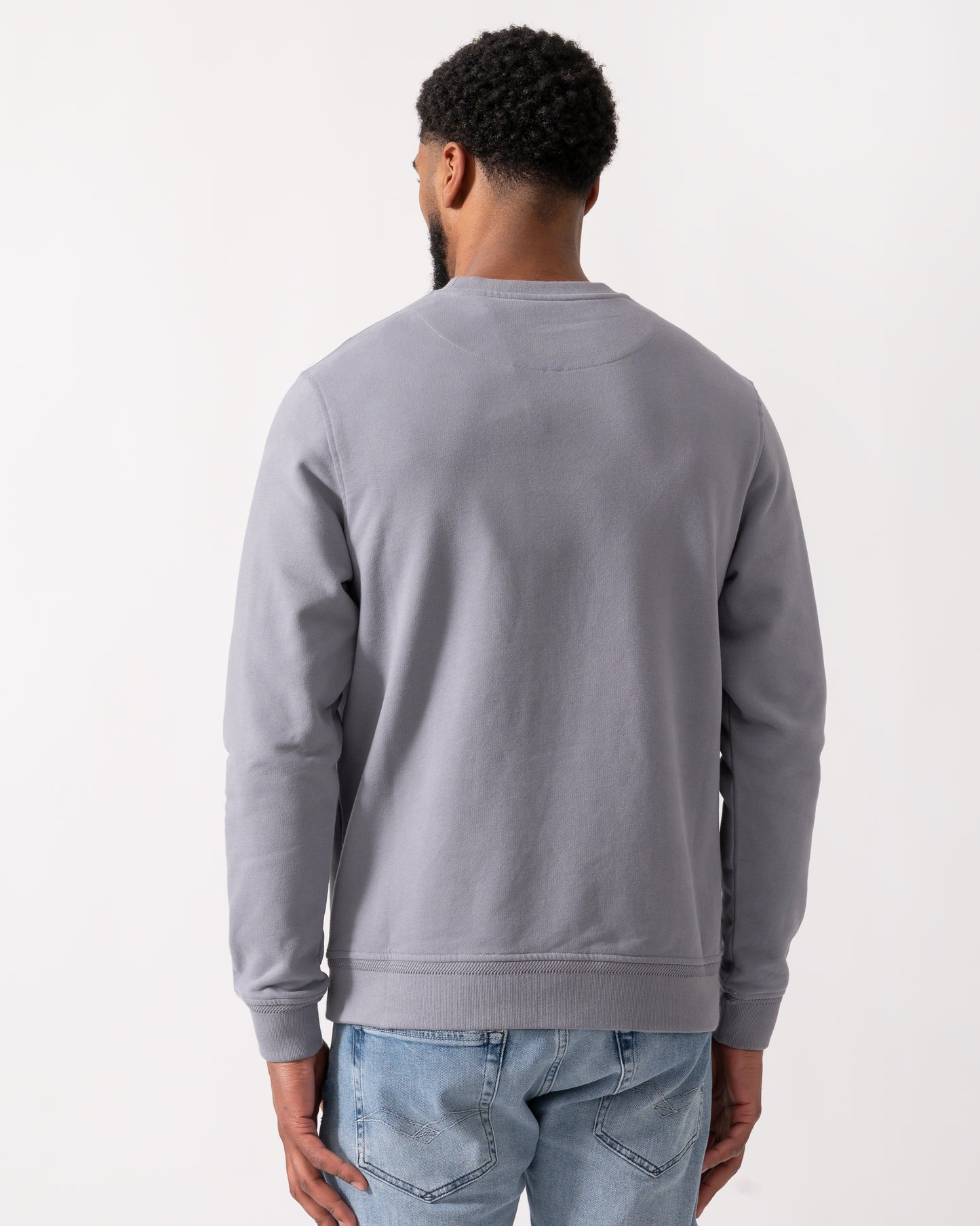 back shot of a Model wearing a Belstaff Mens Crew Neck Sweatshirt With Logo Patch in Faded Indigo