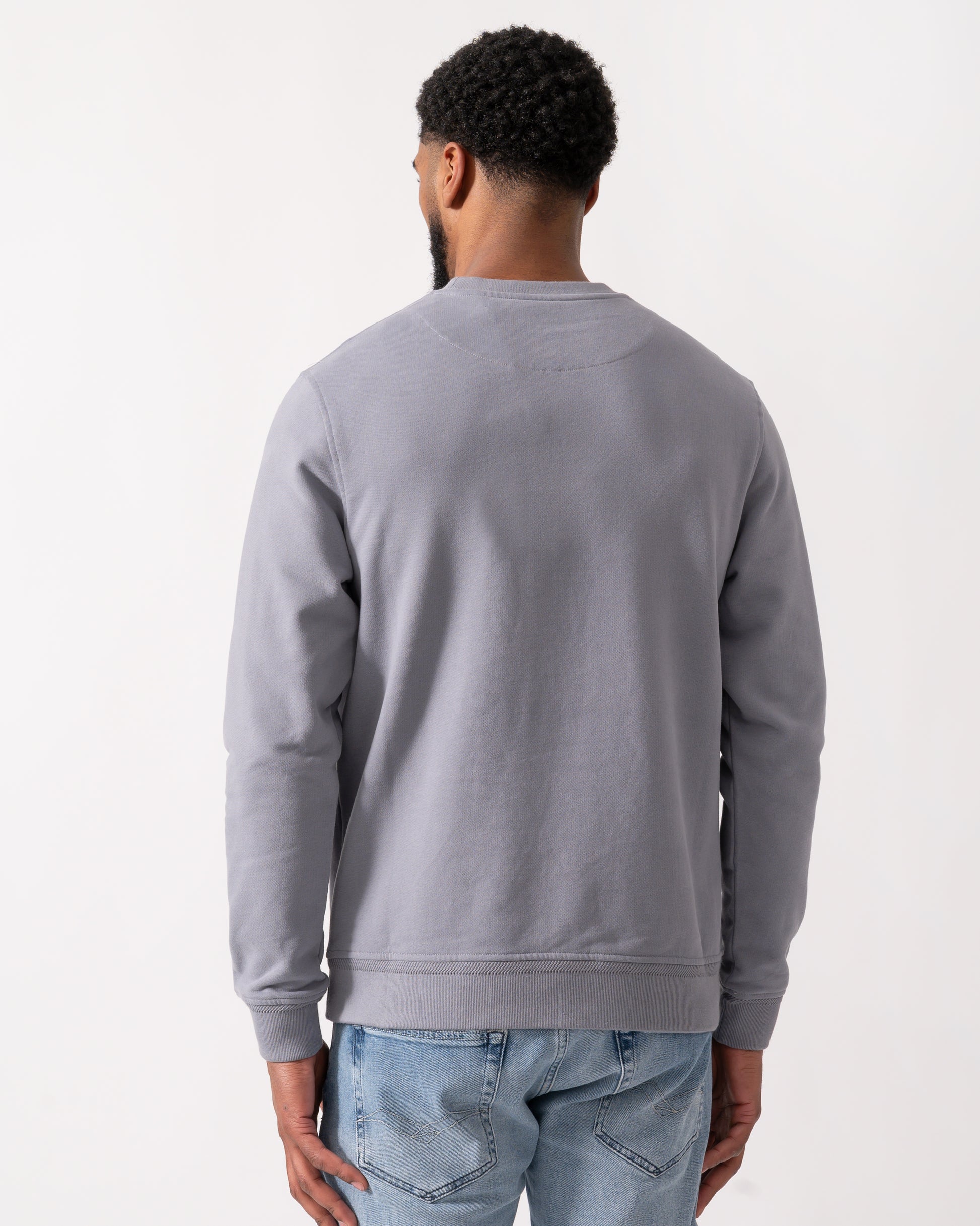 back shot of a Model wearing a Belstaff Mens Crew Neck Sweatshirt With Logo Patch in Faded Indigo