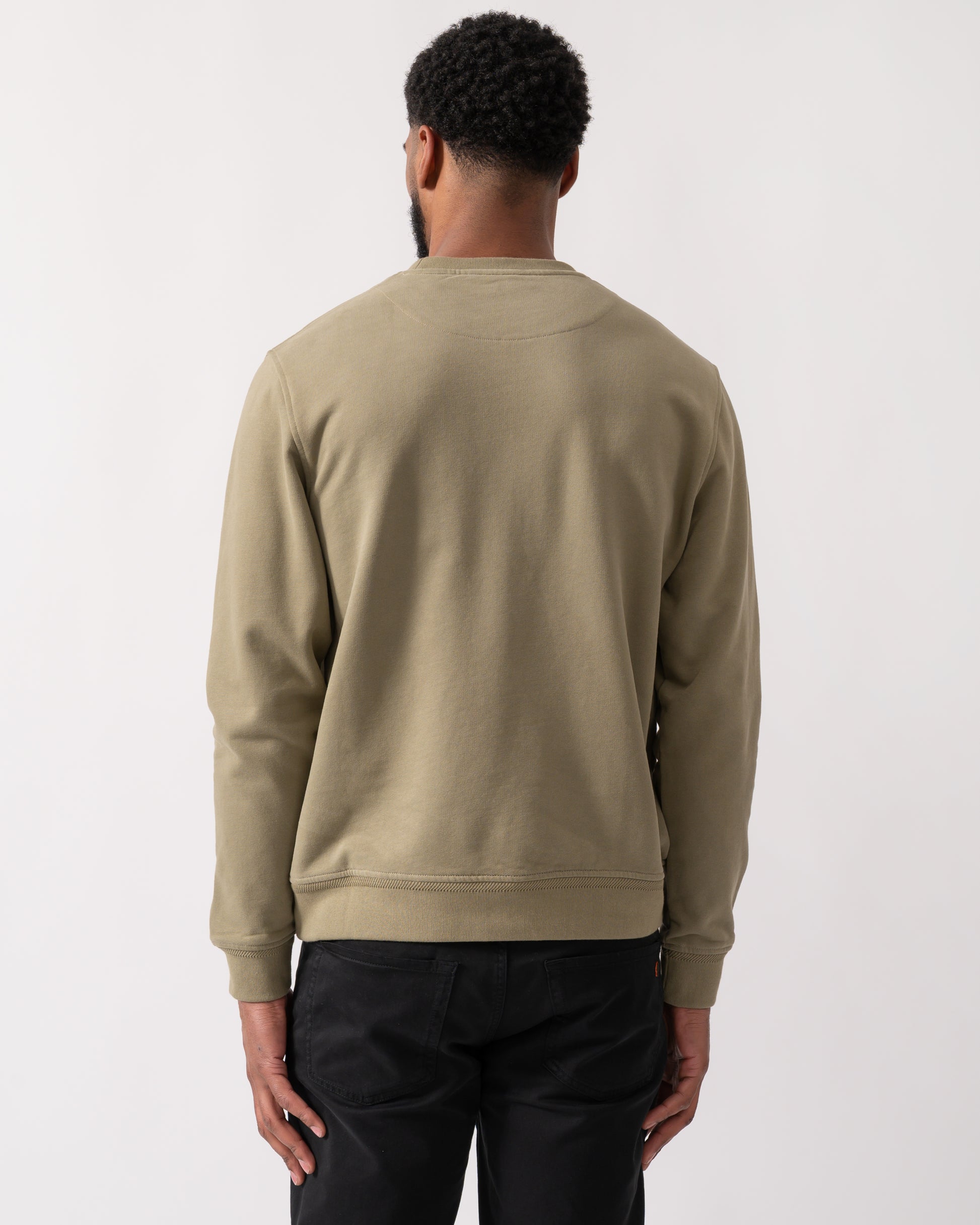 back shot of a model wearing a Belstaff Mens Crew Neck Sweatshirt With Logo Patch in Fatigue Green