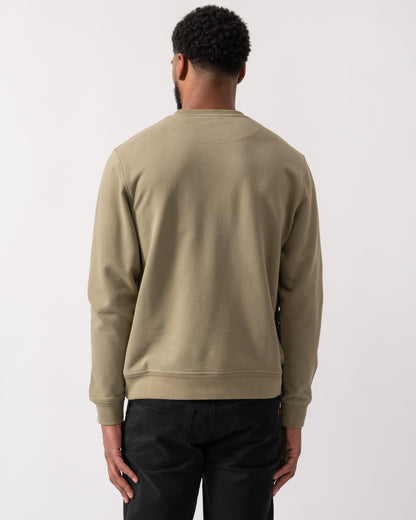 back shot of a model wearing a Belstaff Mens Crew Neck Sweatshirt With Logo Patch in Fatigue Green