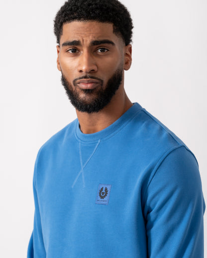 close up of a model wearing Belstaff Mens Crew Neck Sweatshirt With Logo Patch in Marine Blue
