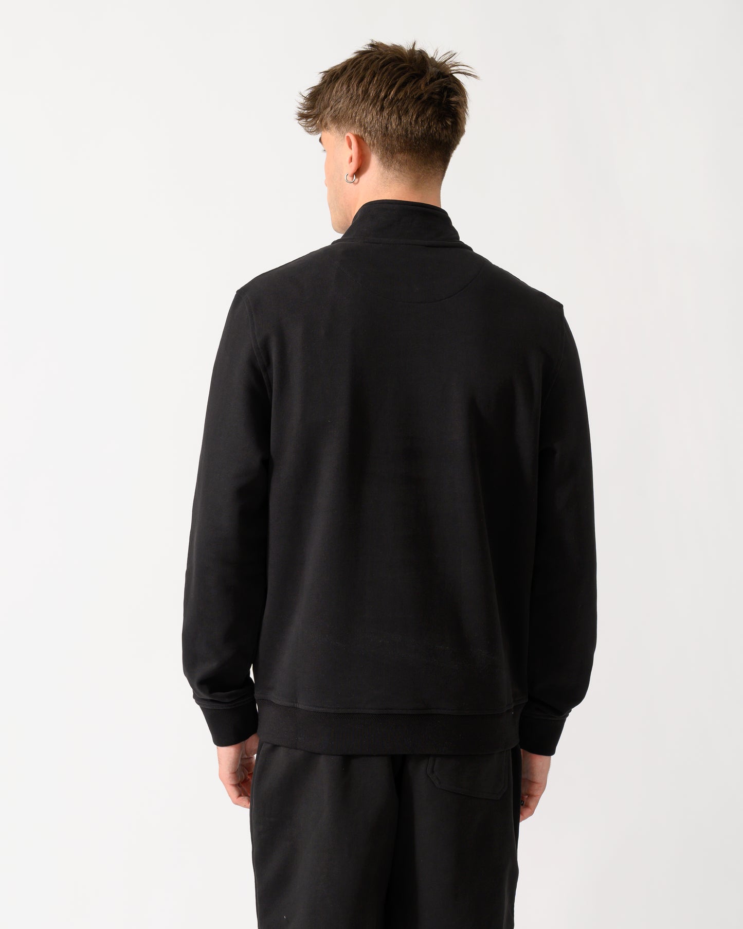 back shot of a model wearing a Belstaff Mens Logo Quarter Zip Sweatshirt in Black