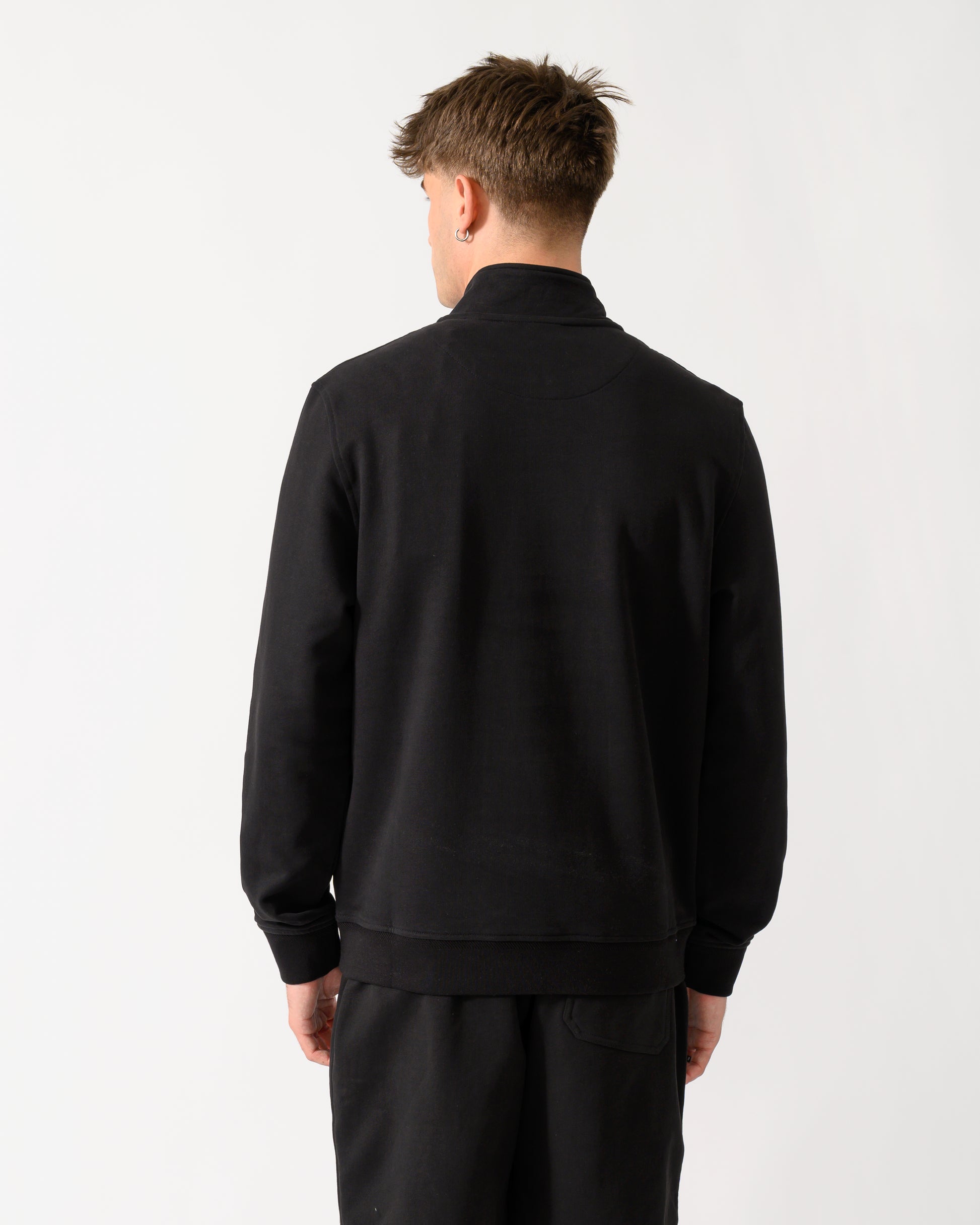 back shot of a model wearing a Belstaff Mens Logo Quarter Zip Sweatshirt in Black