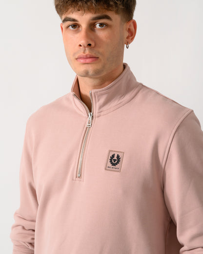 close up shot of a model wearing a Belstaff Mens Logo Quarter Zip Sweatshirt in Dusk Pink