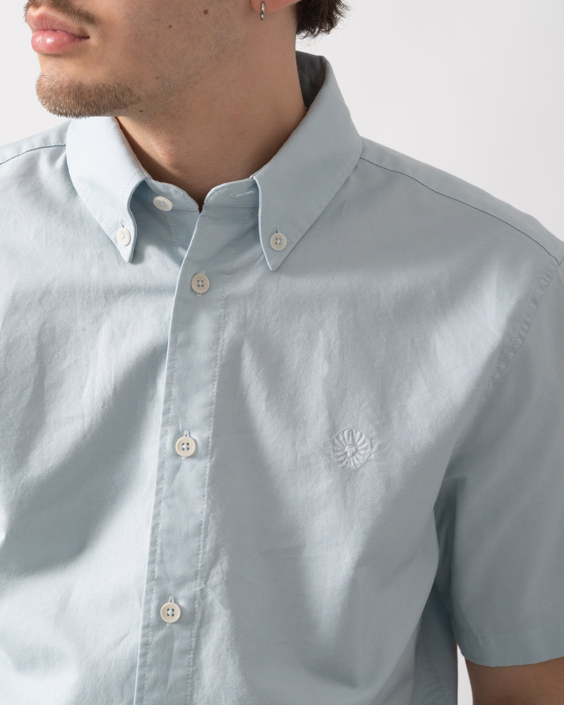 detail shot of a model wearing a Belstaff Mens Short Sleeve Street Shirt in Sky Blue