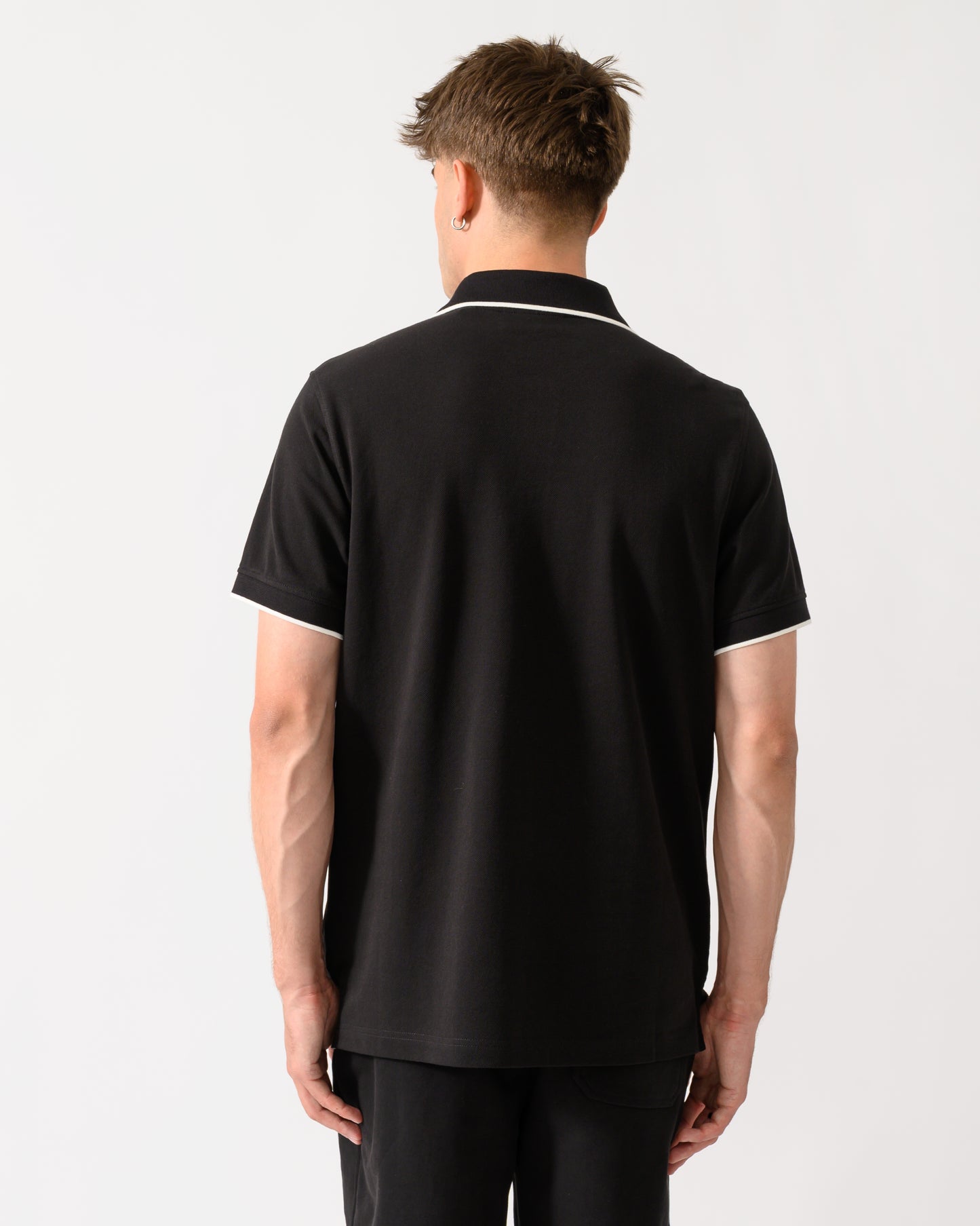 back shot of a model wearing a Belstaff Mens Tipped Polo Shirt in Black