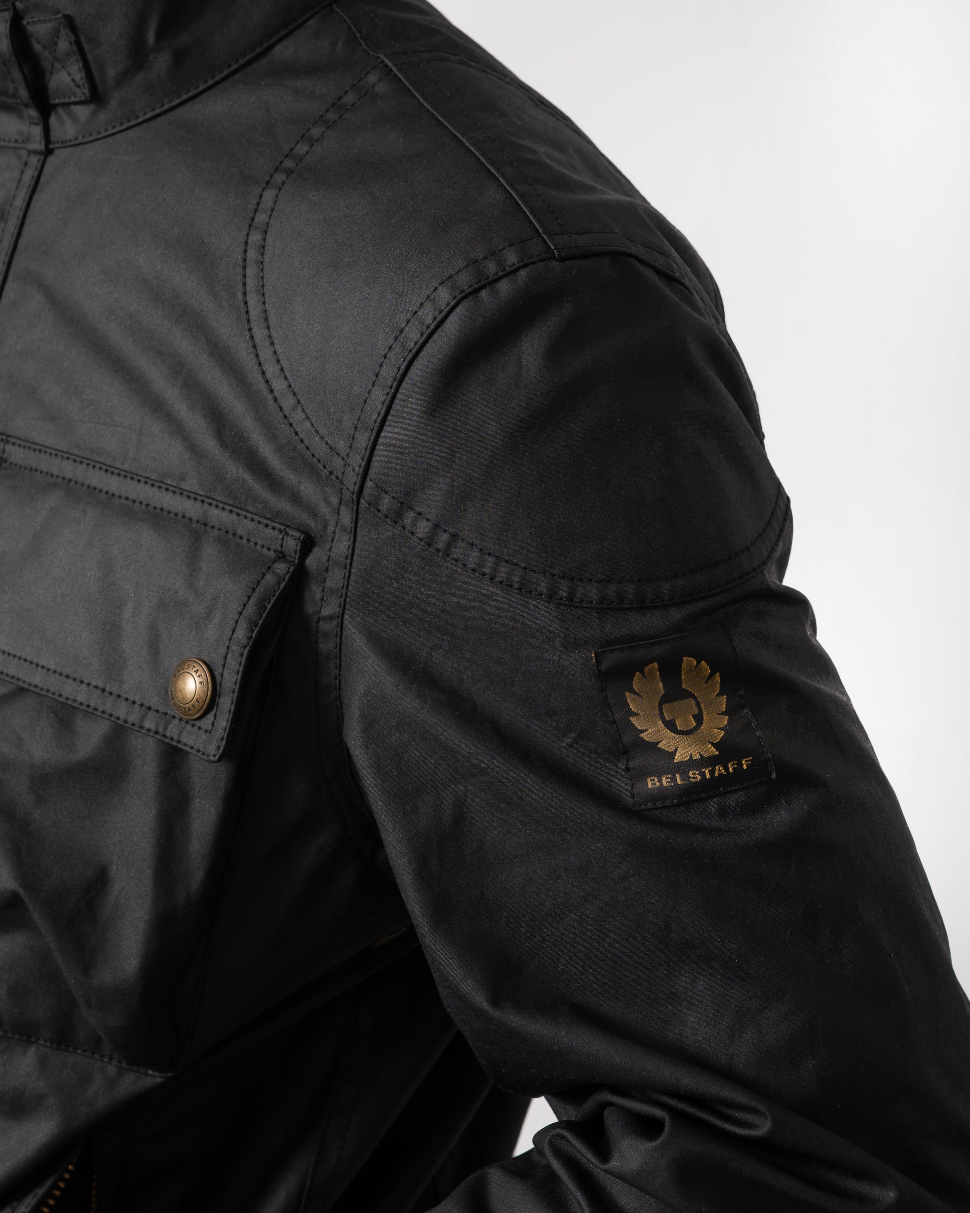logo detail of a Belstaff Racemaster Mens Waxed Cotton Compact Field Jacket in Black