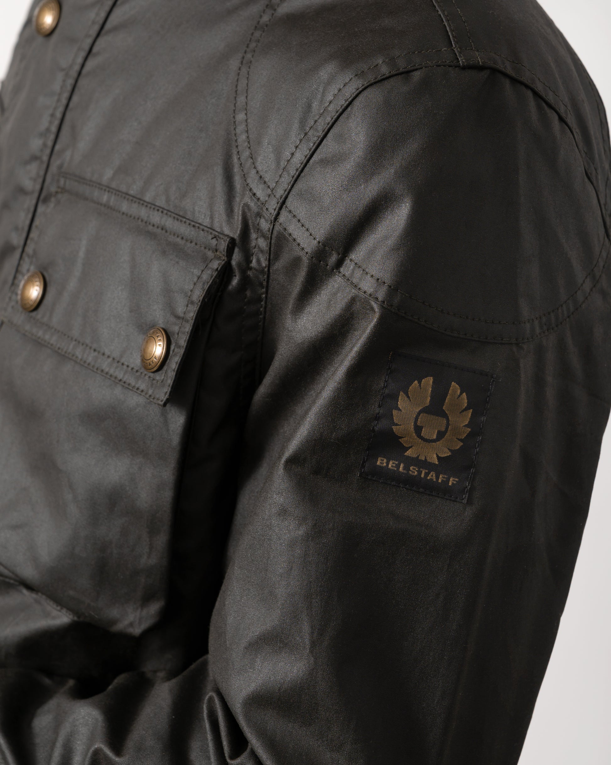 logo detail of a Belstaff Racemaster Mens Waxed Cotton Compact Field Jacket in Faded Olive