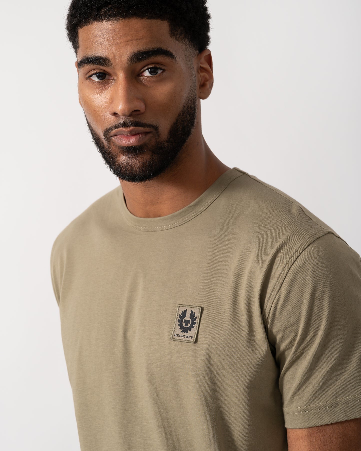 Close up shot of a Model wearing a Belstaff Short Sleeved Mens Logo Patch T-Shirt in Fatigue Green