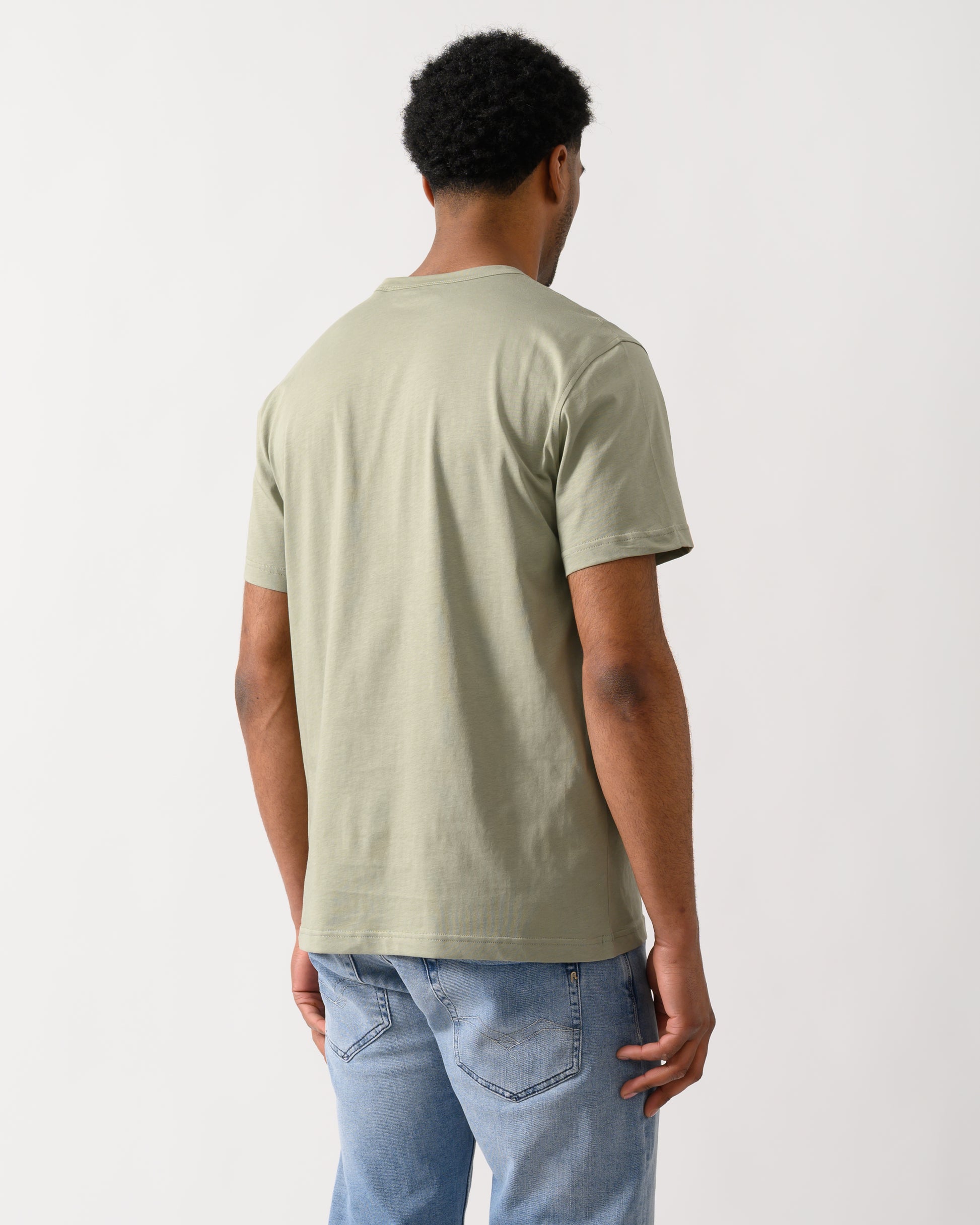 rear view of a Model wearing a Belstaff Short Sleeved Mens Logo Patch T-Shirt in Lichen colour
