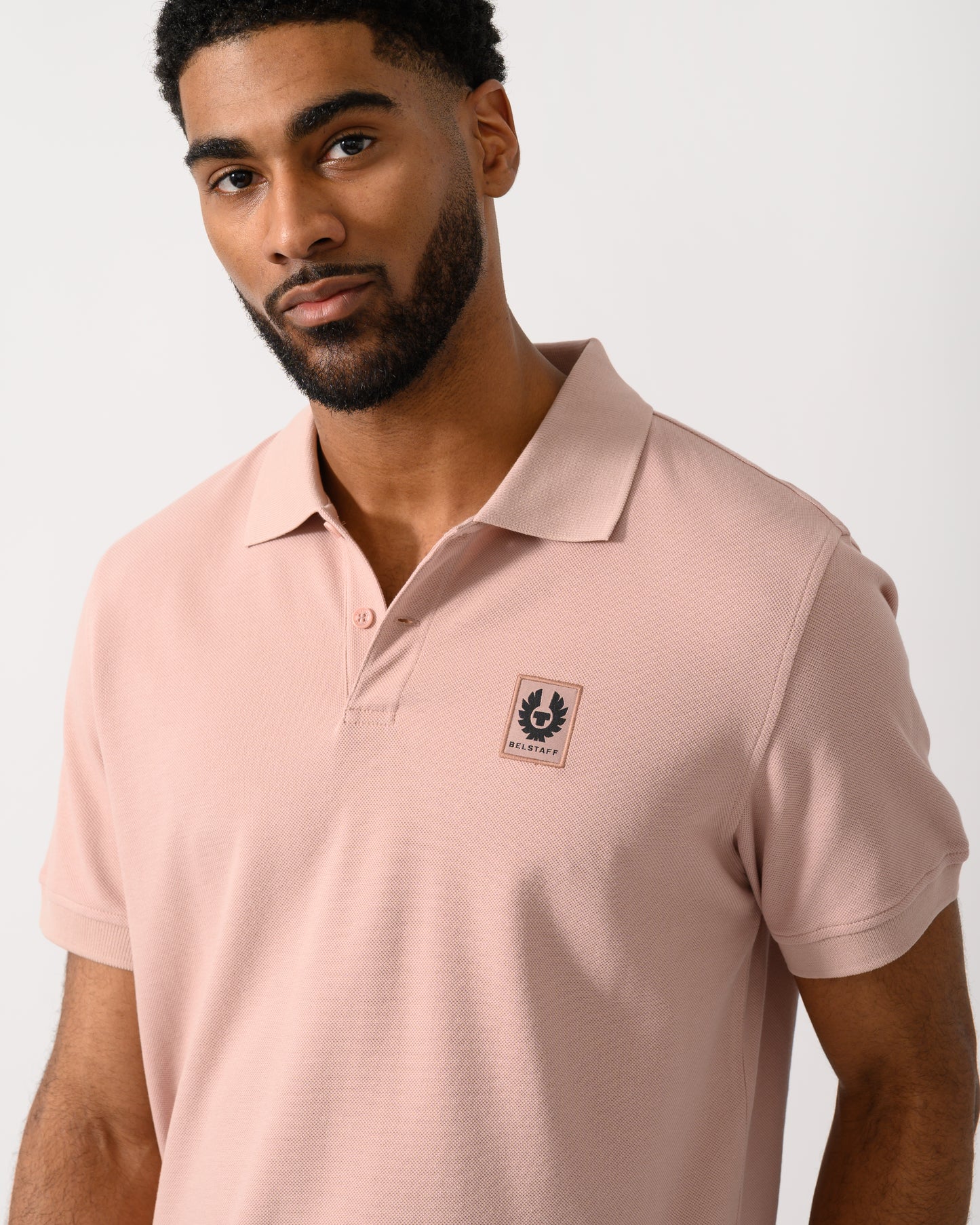 detail shot of a Model wearing a Belstaff Short Sleeved Mens Polo in Dusk Pink