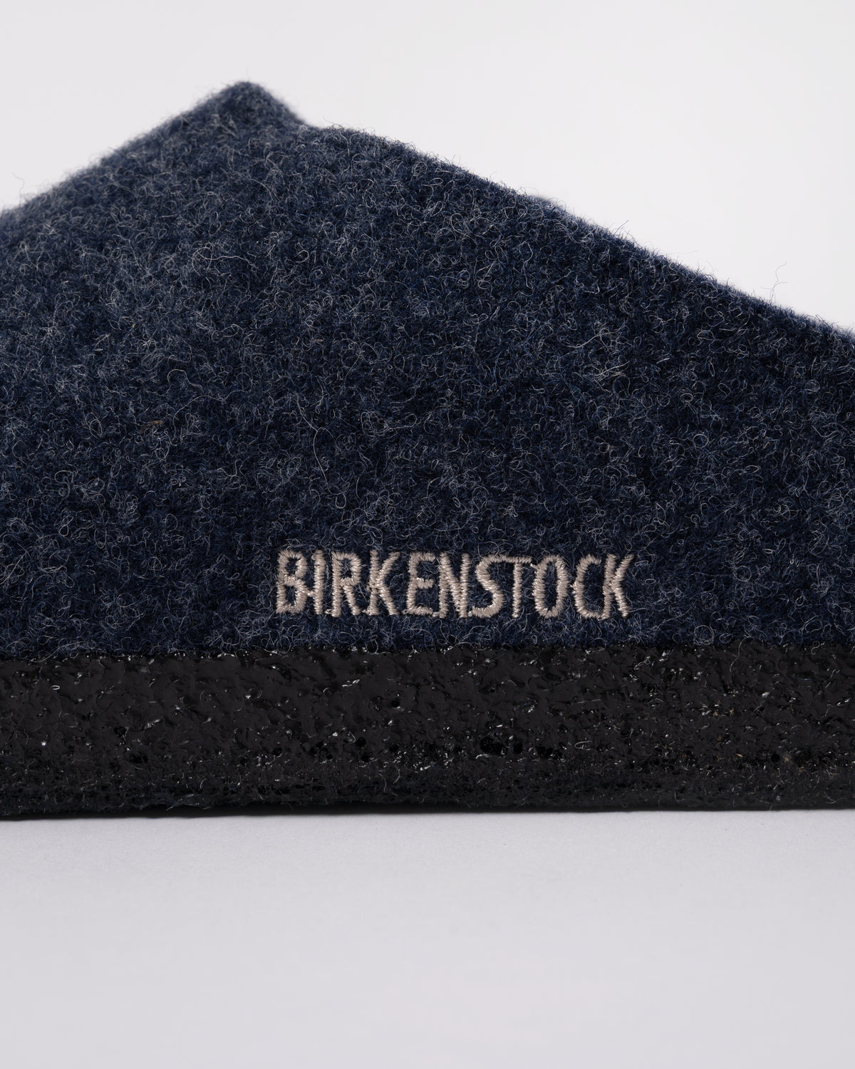 Studio photograph showing a logo detail of Birkenstock Zermatt Shearling FE Womens Clogs  Dark Bluen