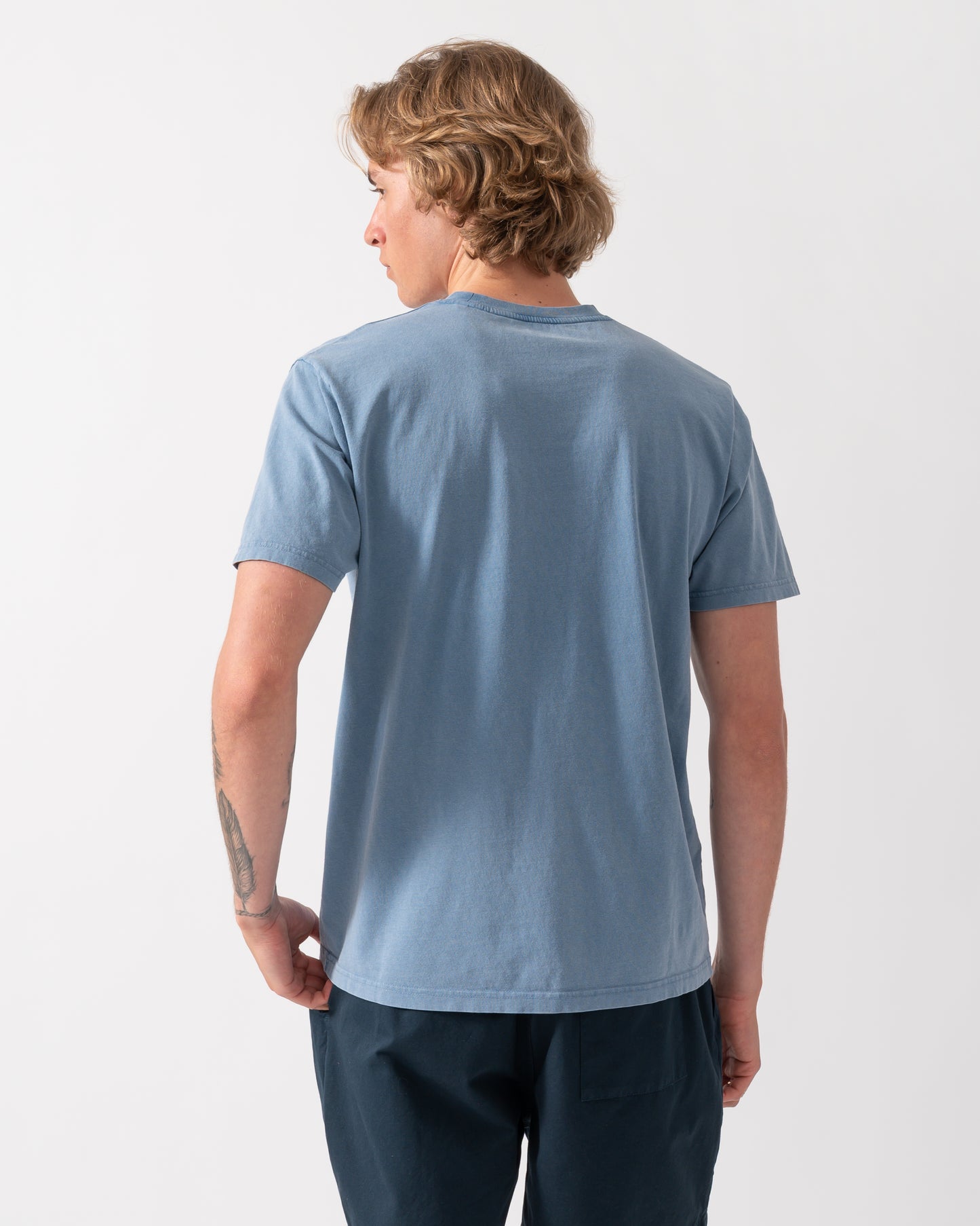 back shot of a model wearing a Colorful Standard Classic Organic T-Shirt in Faded Indigo