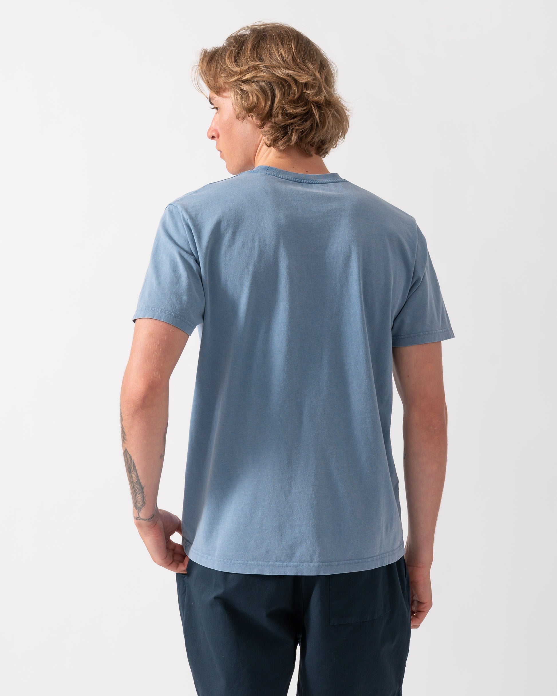 back shot of a model wearing a Colorful Standard Classic Organic T-Shirt in Faded Indigo