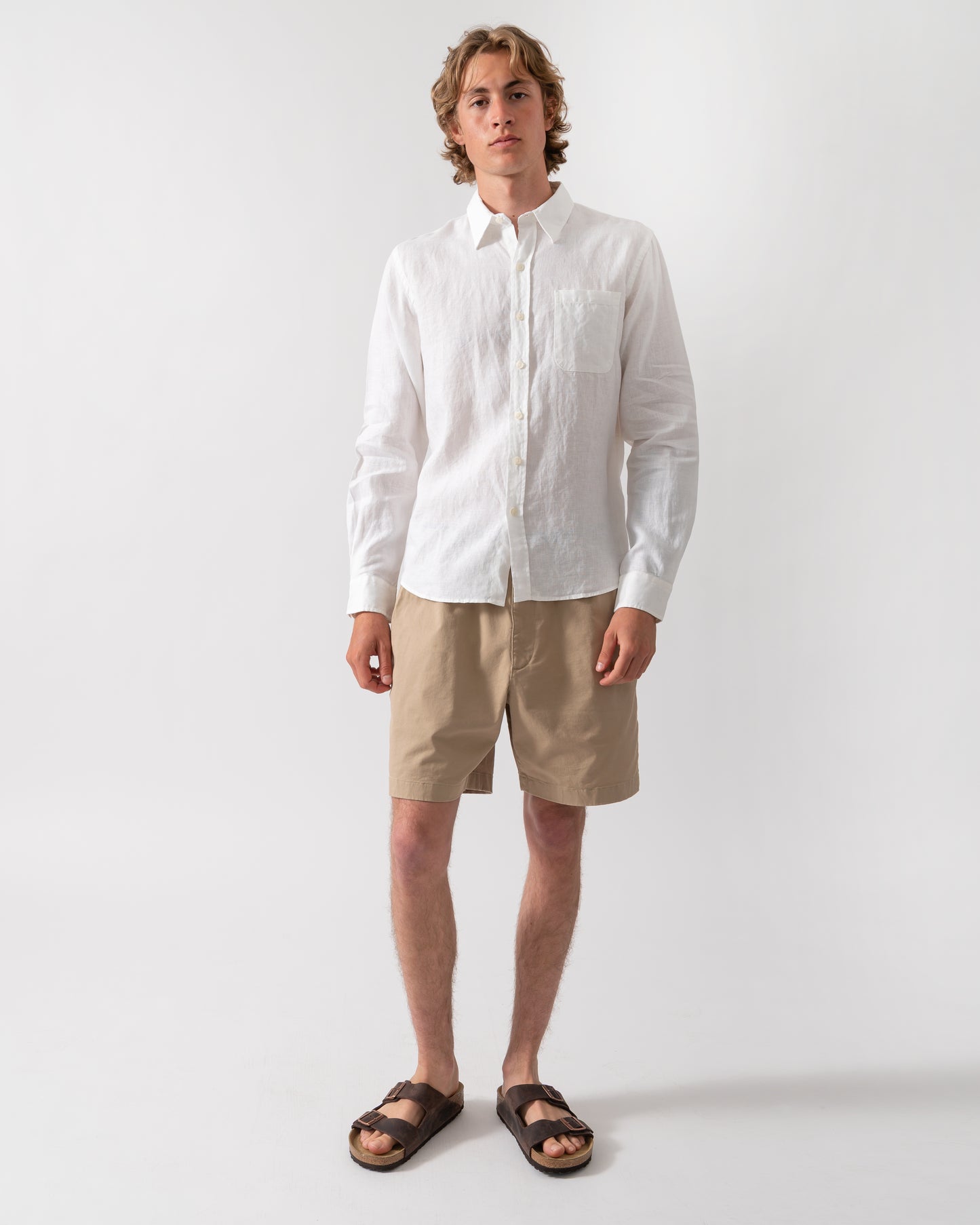 full length shot of a model wearing a Colorful Standard Mens Long Sleeve Linen Shirt in Optical White